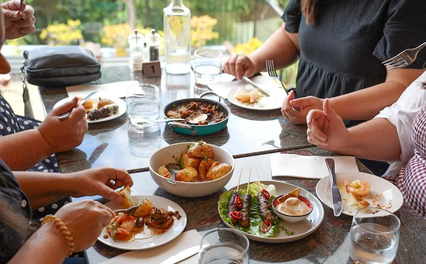 Friends enjoying a shared meal at a local Hawkesbury restaurant near Dido’s Place, featuring fresh dishes and a relaxed dining experience perfect for a girls weekend away.