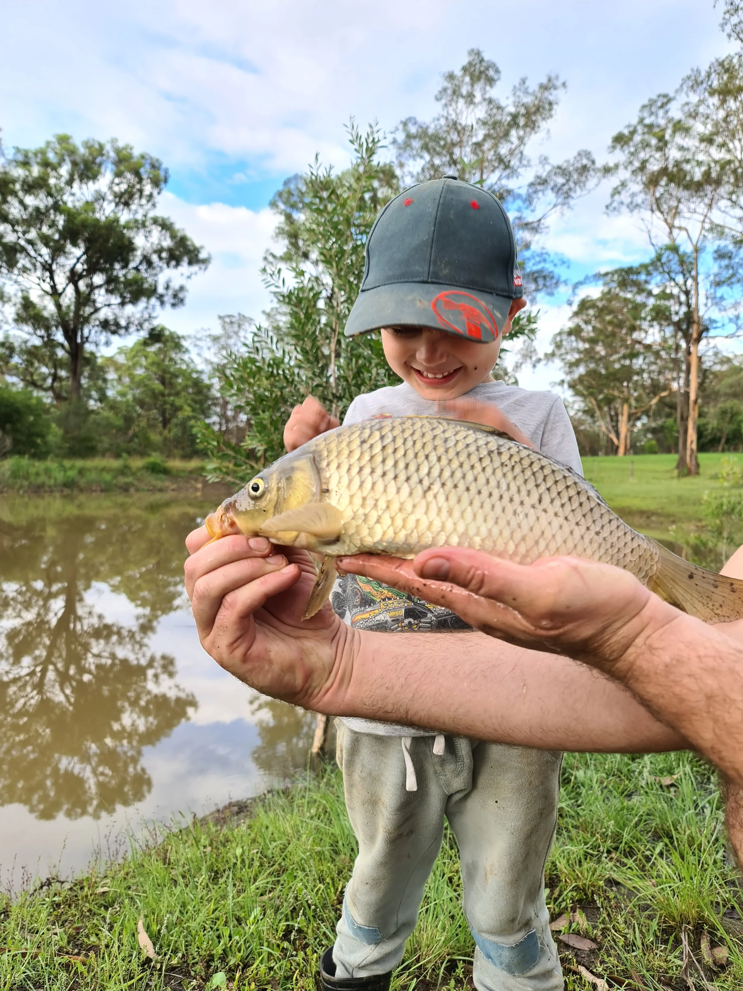 Child proudly holding a fish caught in the private dam at Dido's Place, a family-friendly holiday accommodation in the Hawkesbury near Sydney.