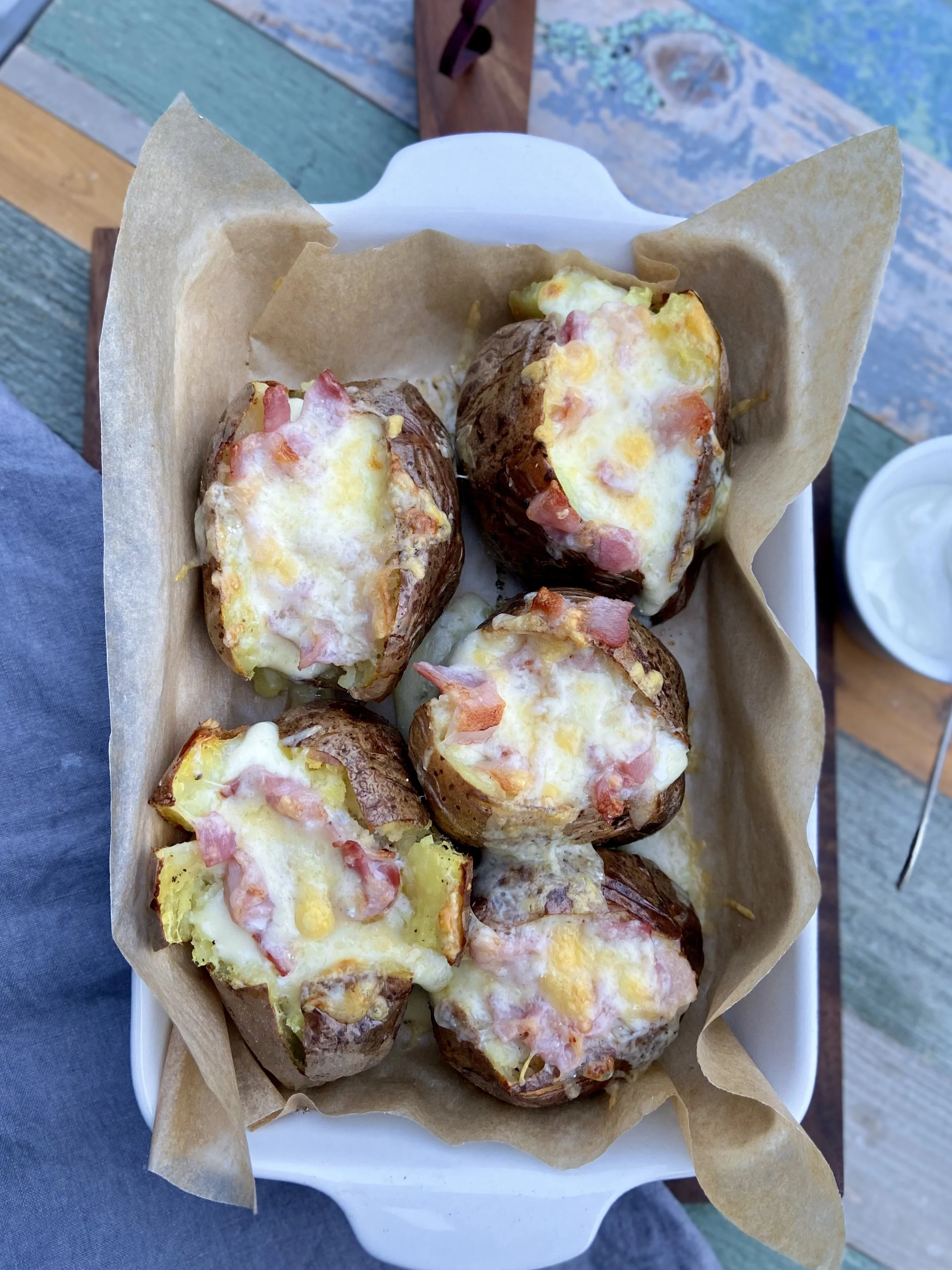 Cepeškrāsnī cepti kartupeļi ar bekonu un diviem sieriem