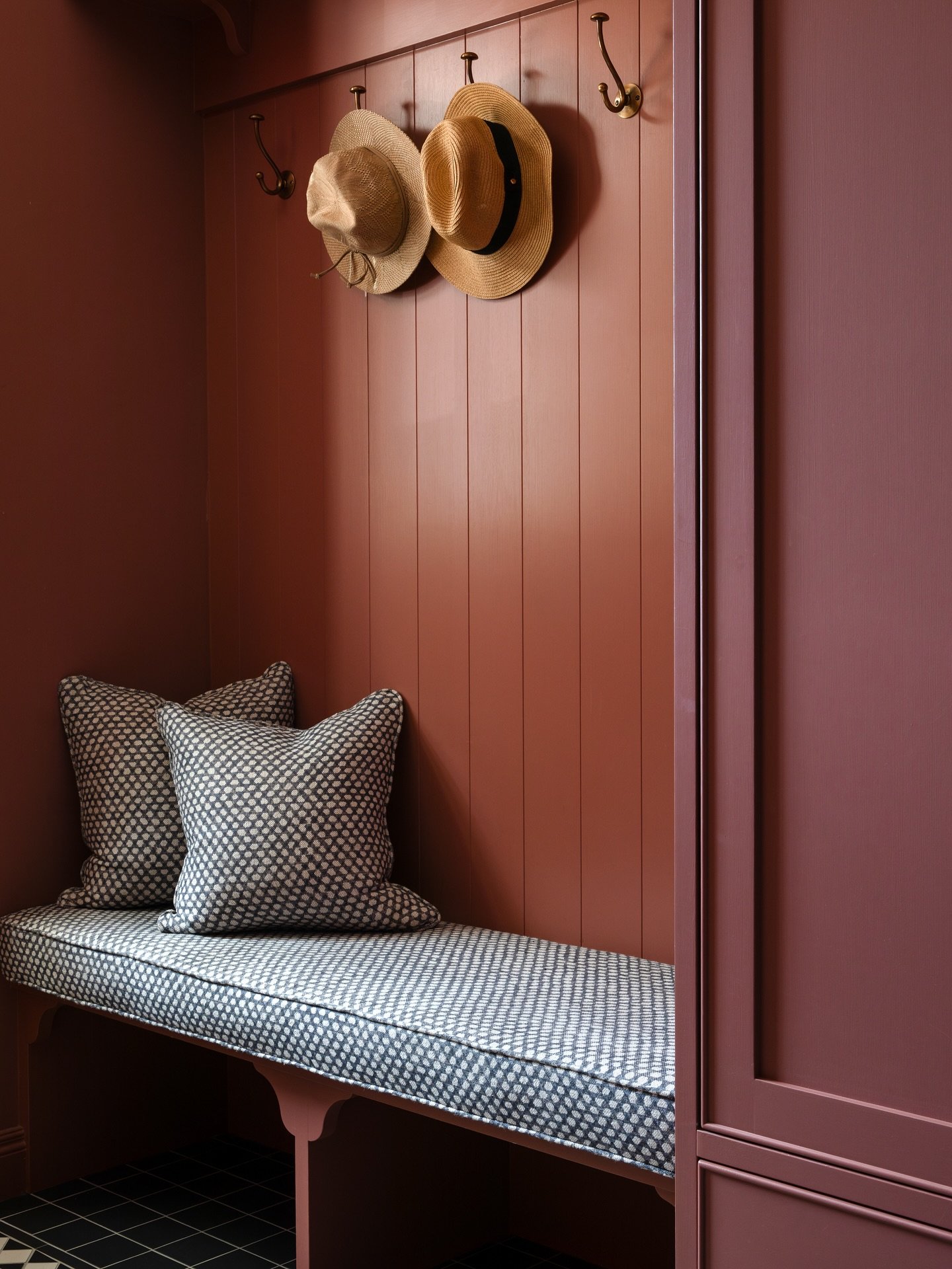 I loved designing this bootroom for our Westview project. Every detail was carefully considered from how the space functions to how it feels. The walls and cabinetry are painted in the same deep rose shade, creating a warm, enveloping backdrop that f