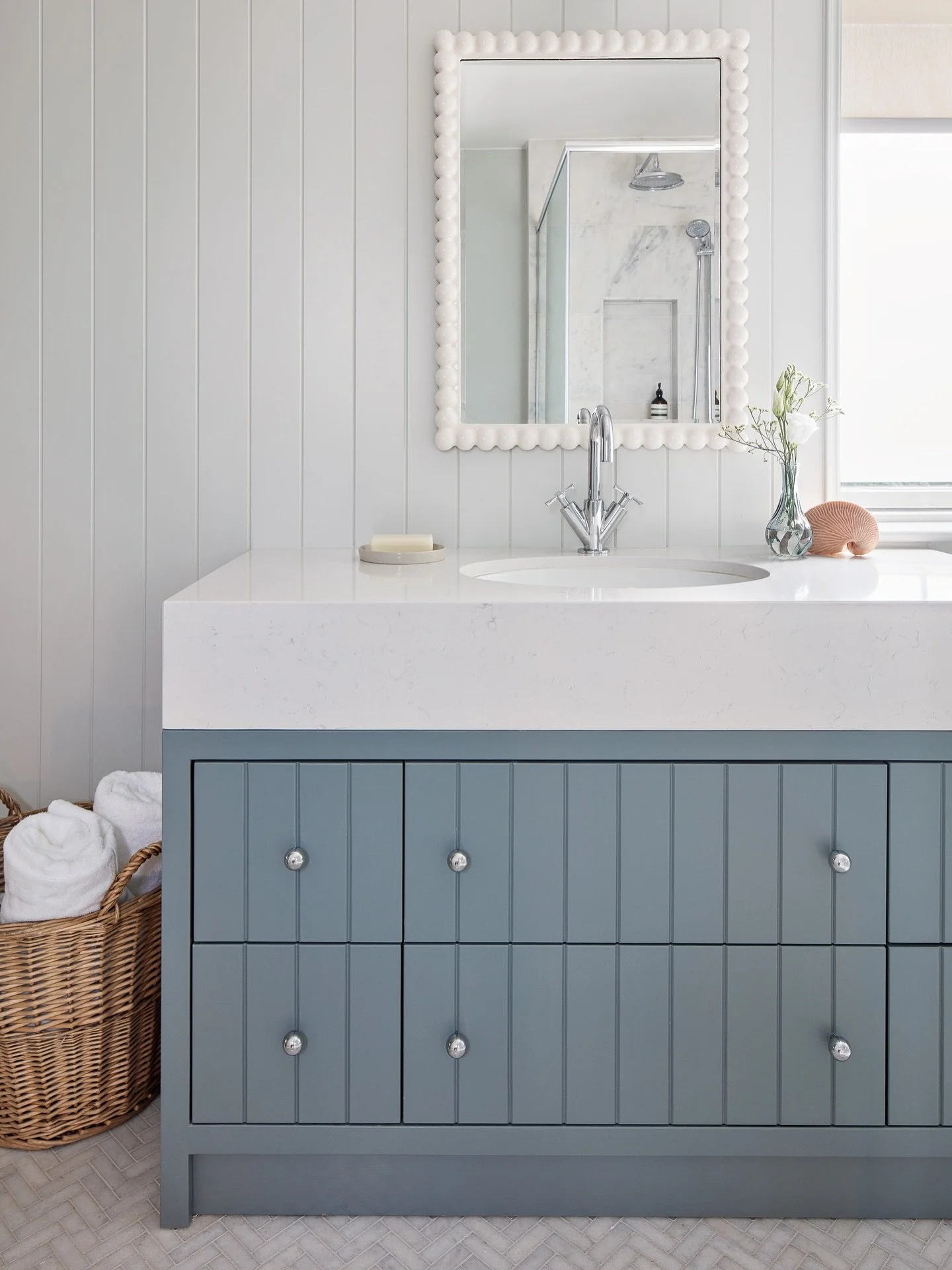 Fresh, timeless and full of quiet detail. The bespoke vanity, painted in a soft blue-grey, adds character against the vertical panelled walls and marble mosaic flooring. Every element was designed to feel calm, functional and joyful. A space that gro