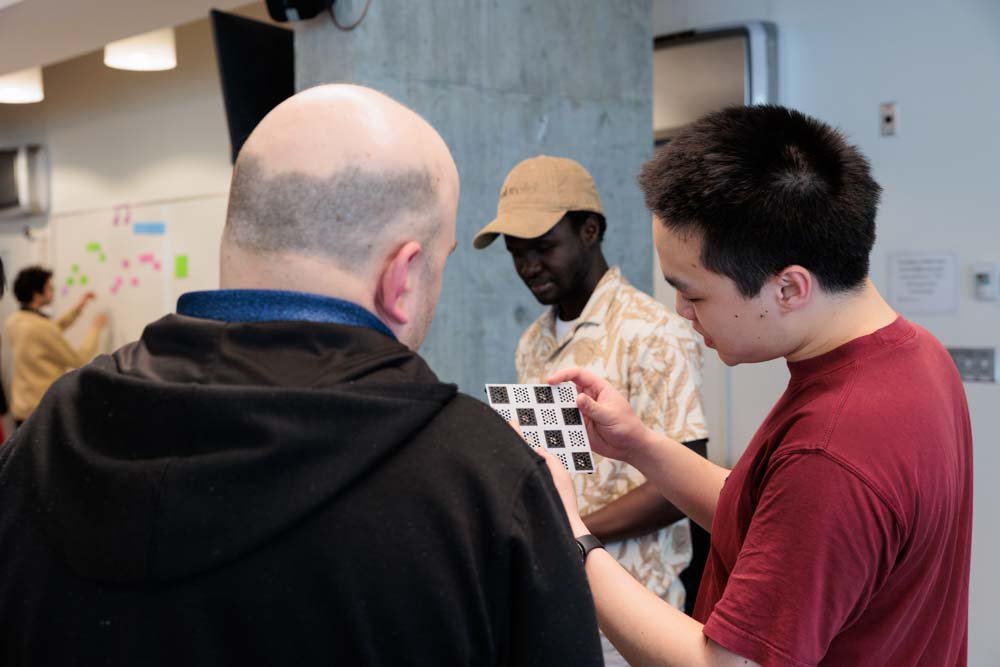 A student demonstrates a 3D-printed component of a chess board