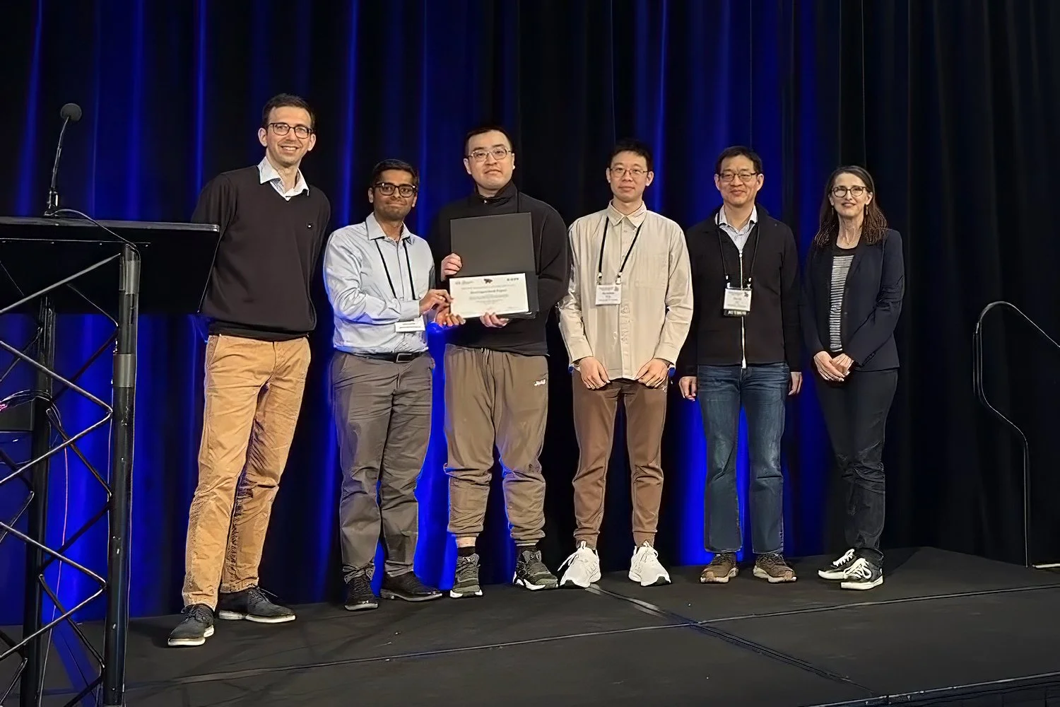 Members of the GPUBreach team stand on stage at IEEE Symposium on Security & Privacy 2026 with their Distinguished Paper Award certificate.