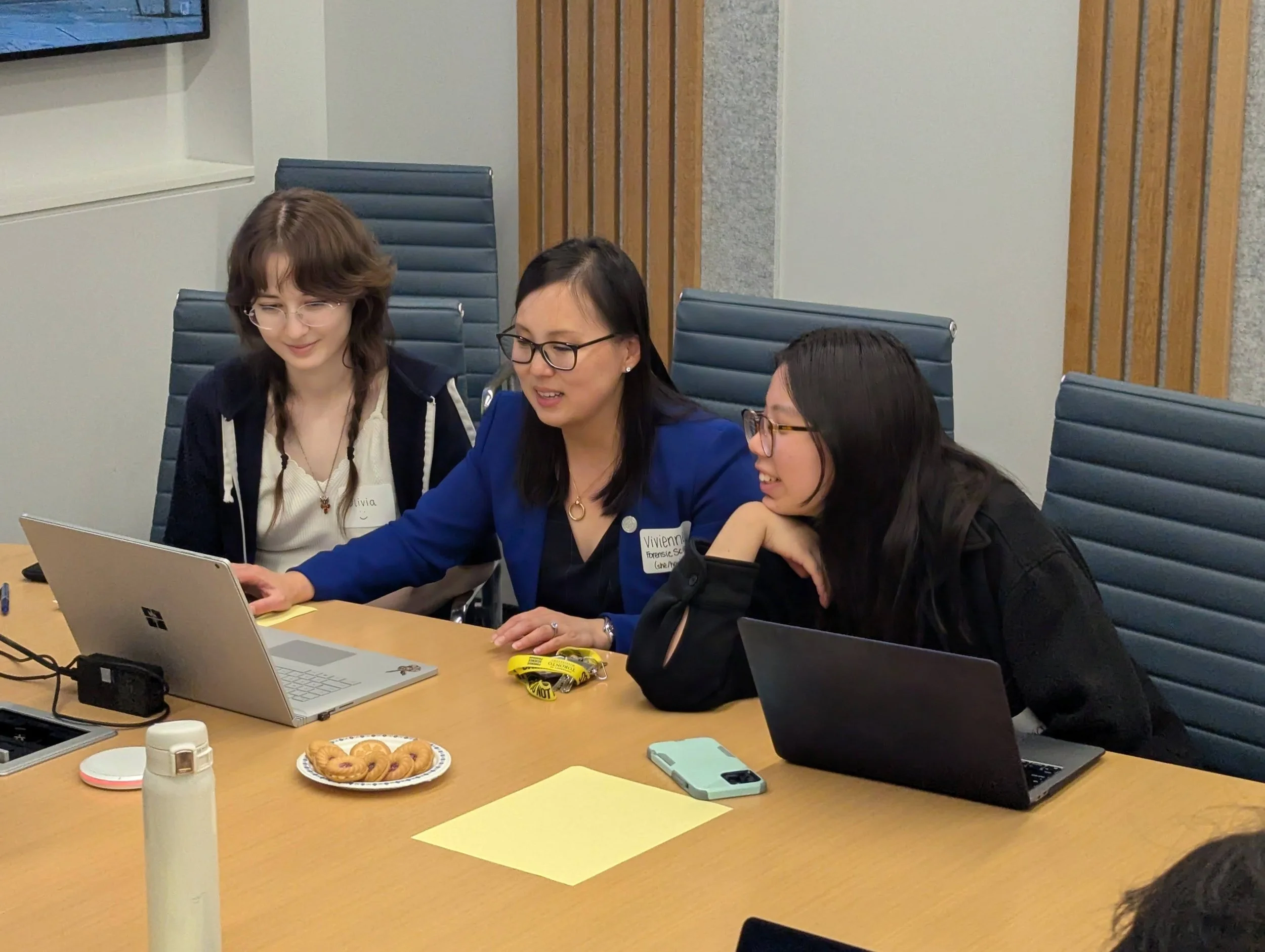 Vivienne Luk with two students looking at a laptop.