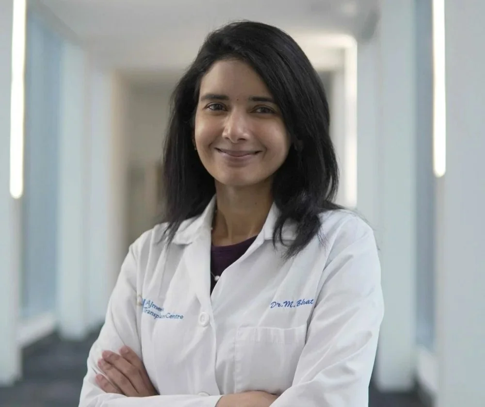 Mamatha Bhat smiles facing the camera with her arms folded.