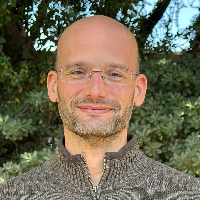 Ohad Shamir smiles facing the camera.