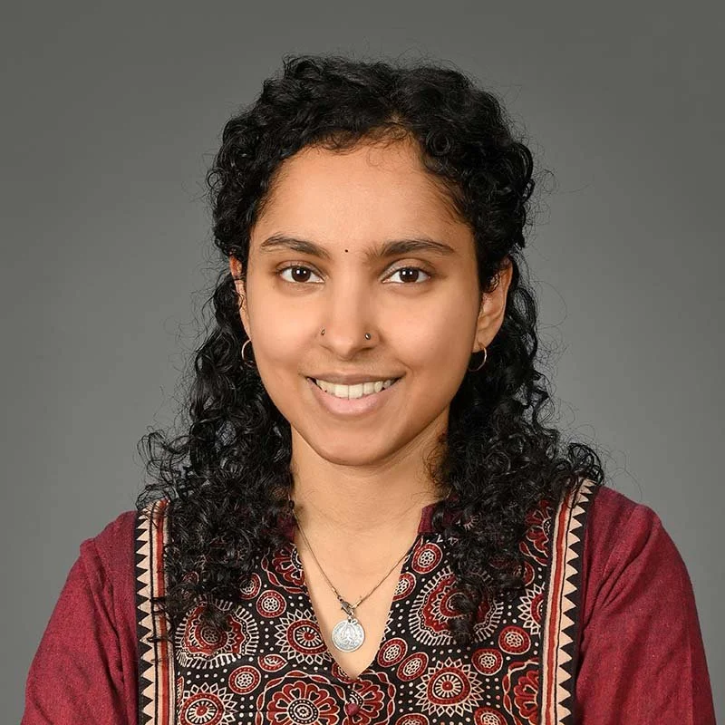 Uma Girish smiles facing the camera.