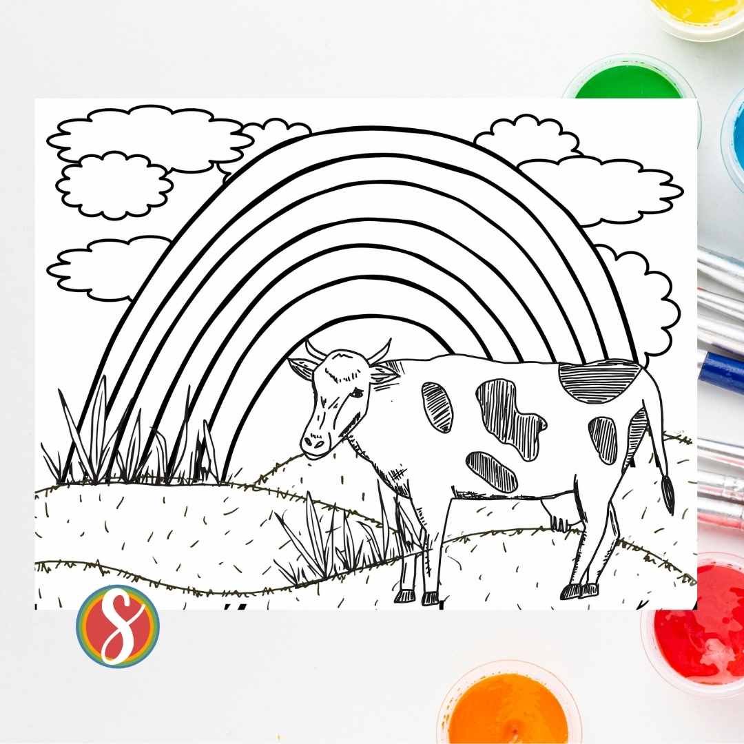 image is a realistic cow coloring page with rainbow and clouds in the background. The coloring page is sitting on a background with paint splotches
