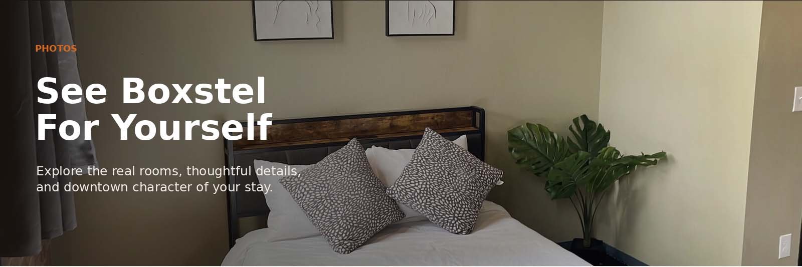 A bedroom with a bed that has white bedding, two patterned pillows, a wooden headboard, a green potted plant on the right, and framed artwork above the bed. Text overlay reading 'See Boxstel For Yourself' and additional description.