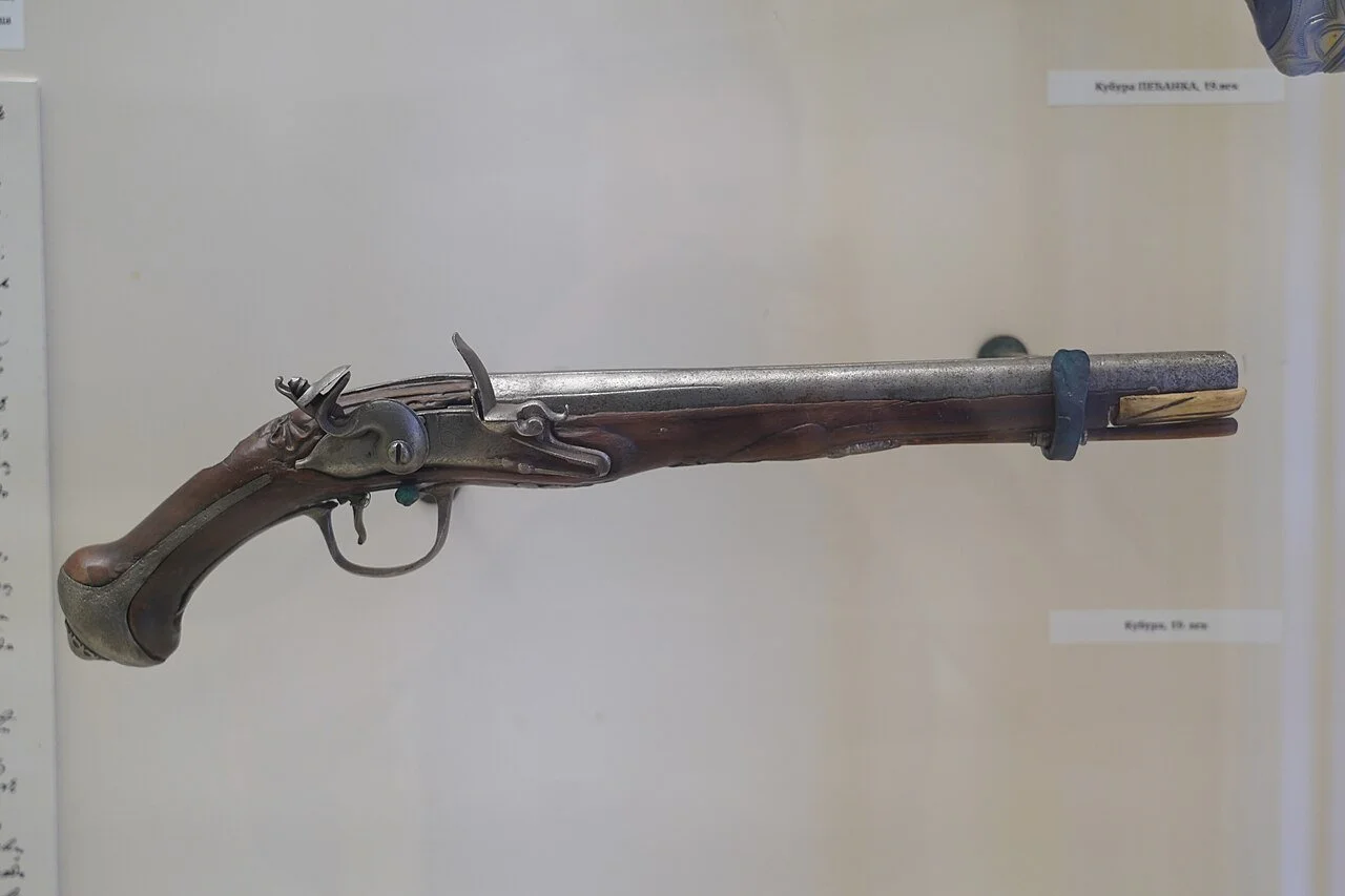 An authentic 18th-century flintlock pistol with a dark wood stock and steel barrel, representing the unreliable weaponry used during the Beast of Gévaudan attacks.