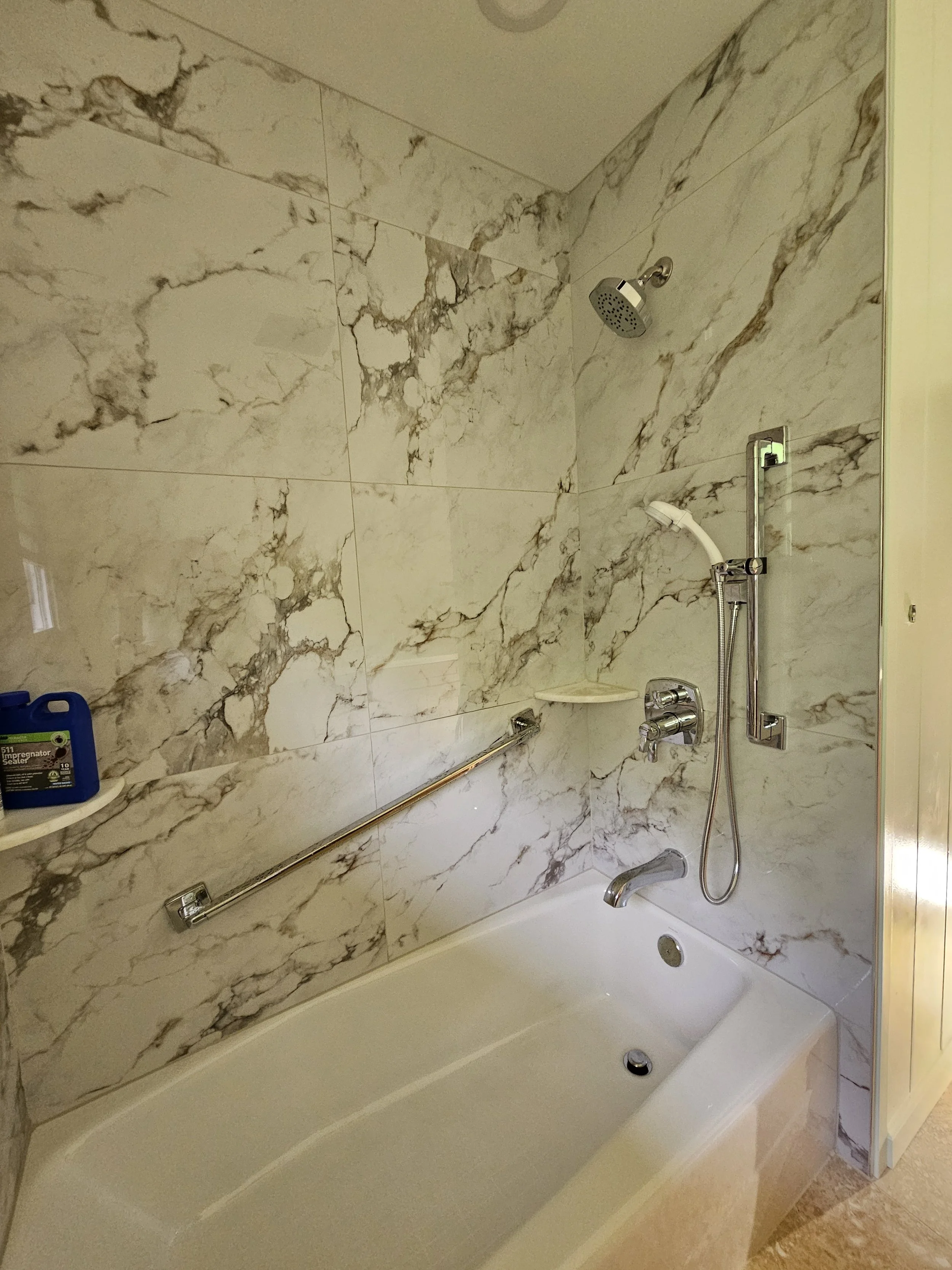 A bathtub with marble wall tiles