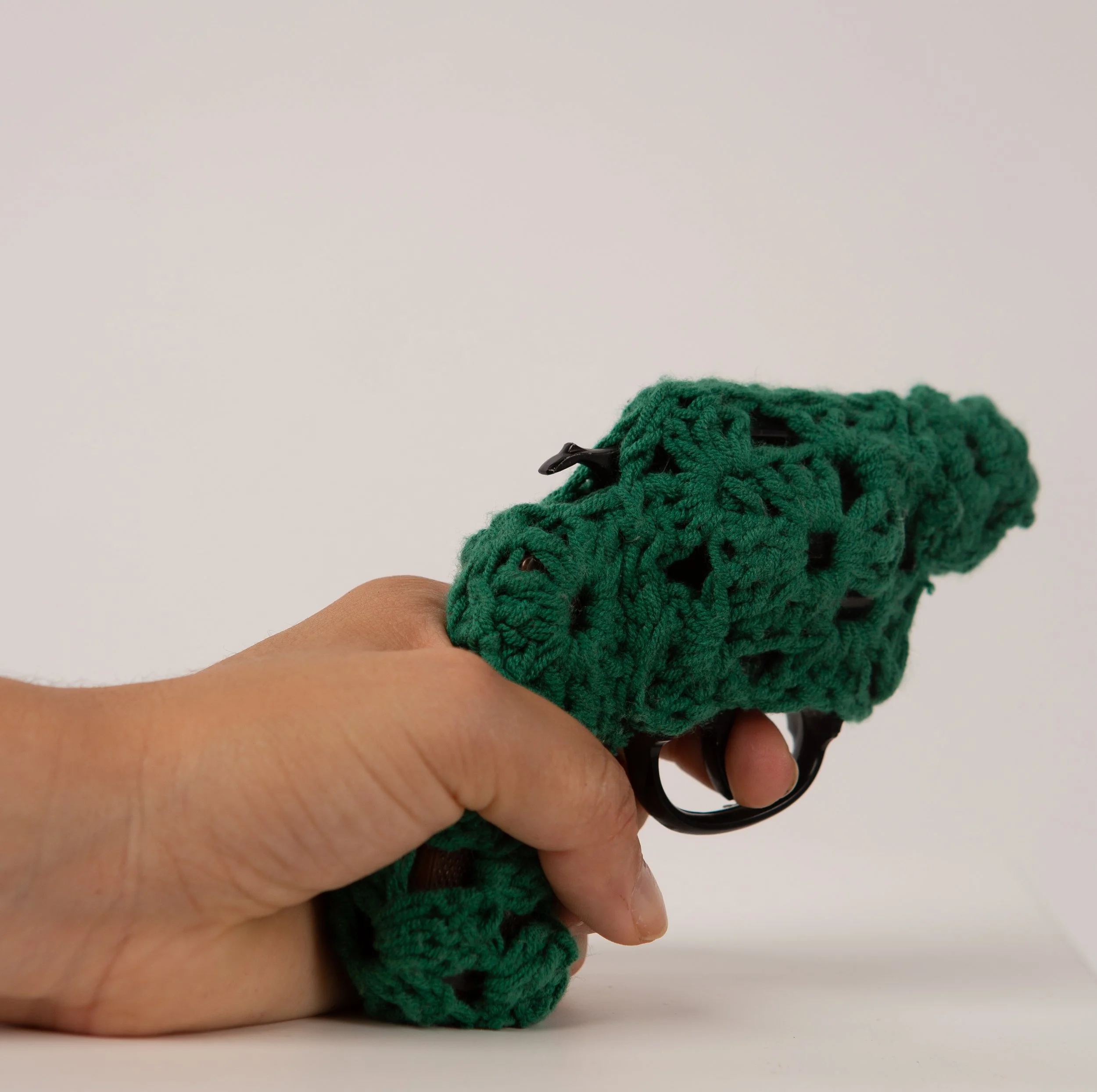 Green gun wrapped in crochet textile sculpture by Paris artist Sophie Inard