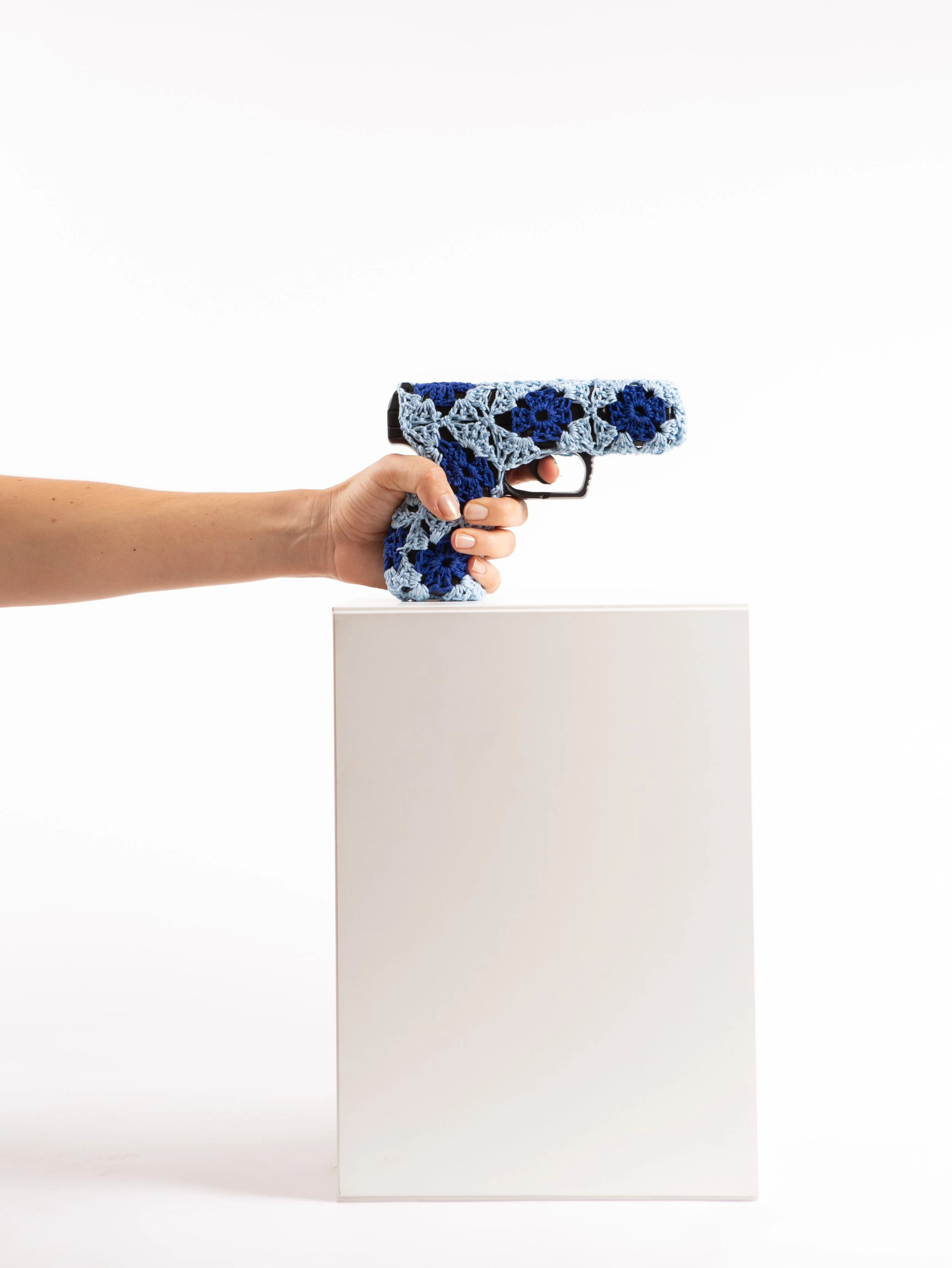 Blue gun wrapped in crochet textile sculpture by Paris artist Sophie Inard