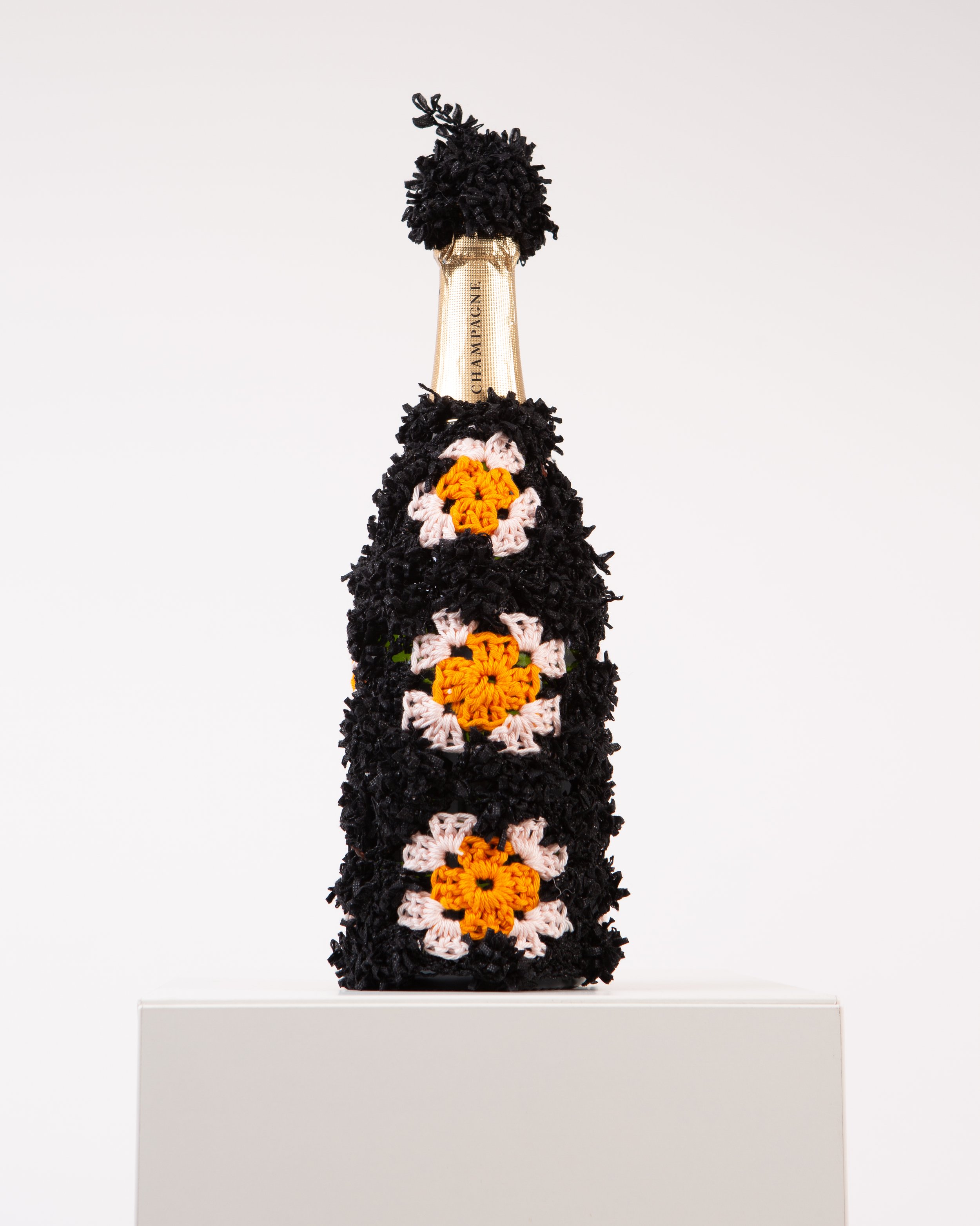 Champagne bottle wrapped in hand-crocheted textile sculpture by Paris artist Sophie Inard