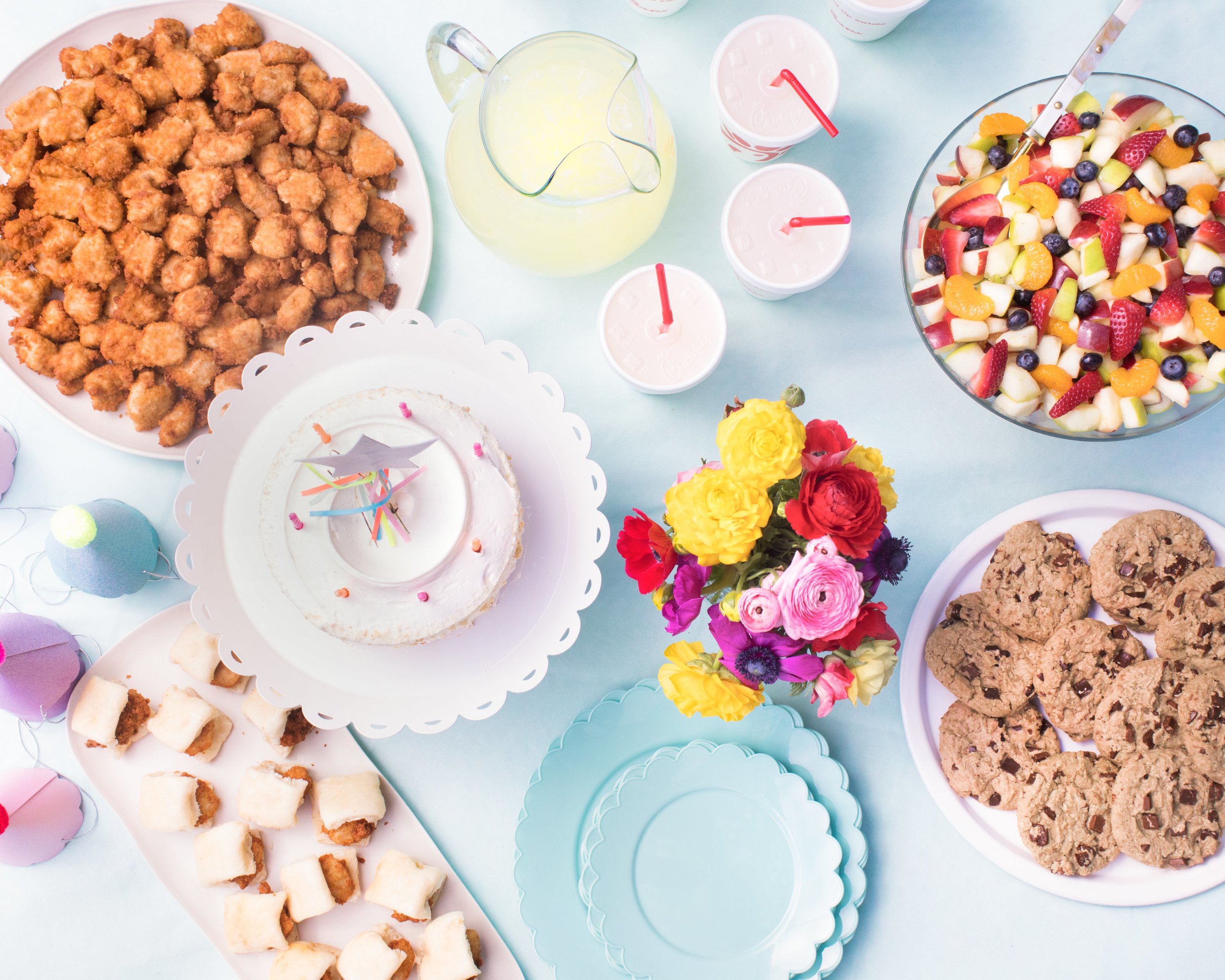 Nuggets and chicken minis at pastel birthday table with flowers