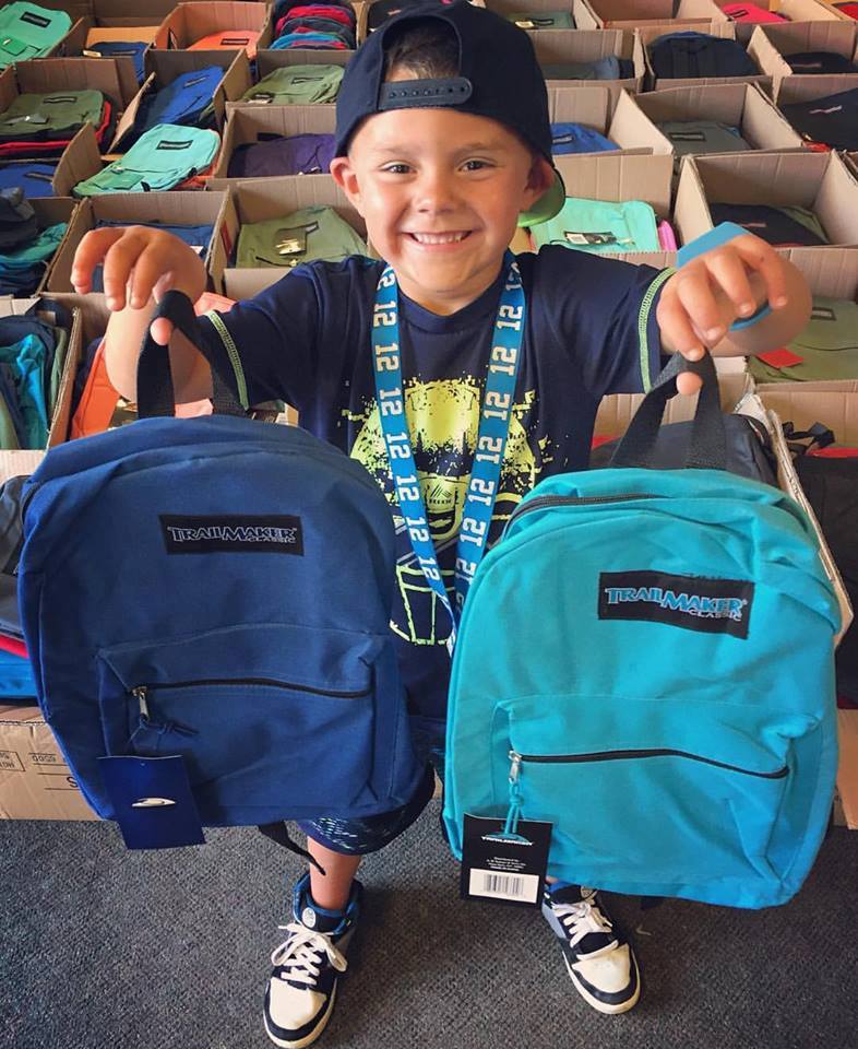 Boy with donated backpacks