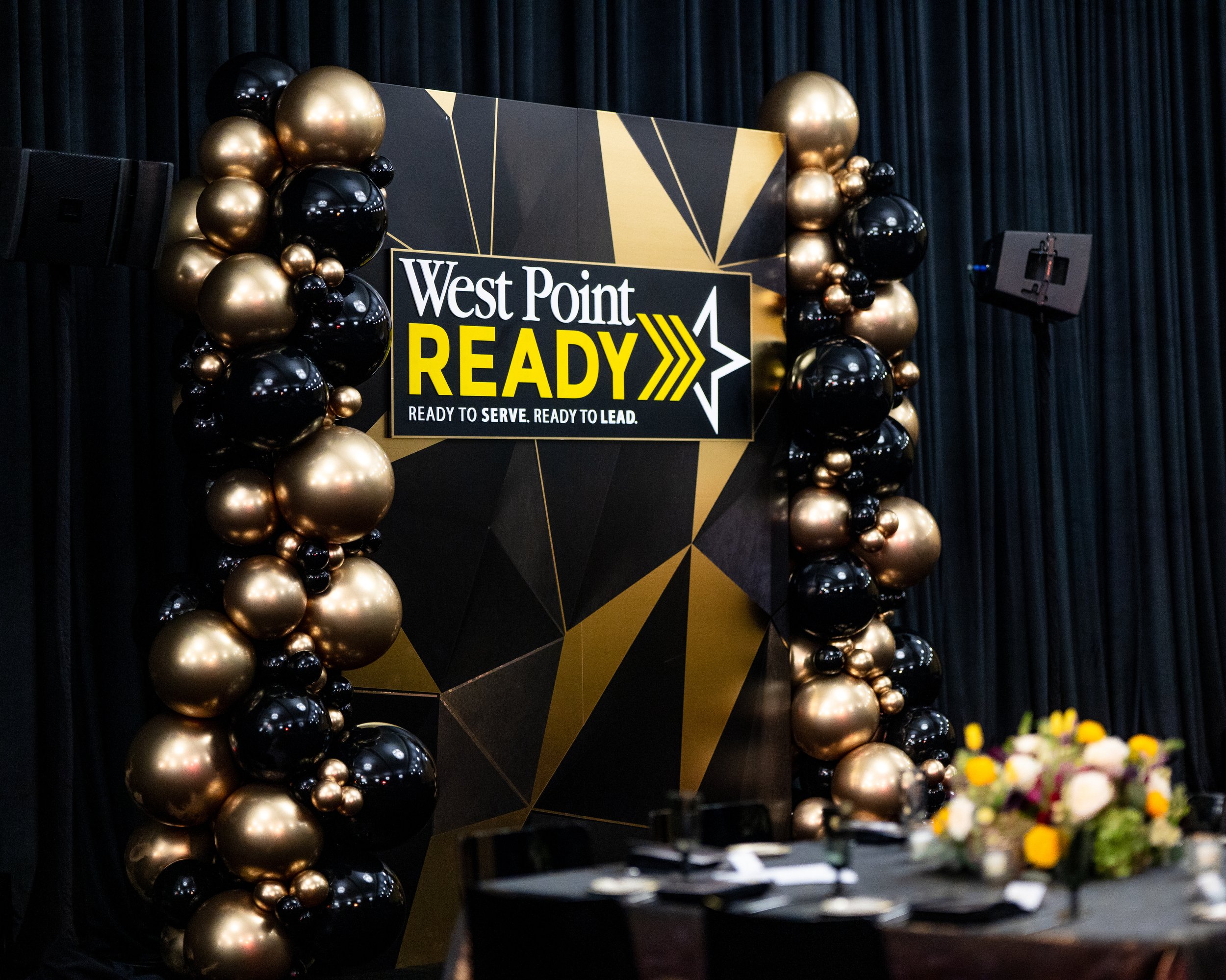 Photo backdrop with West Point logo and balloons