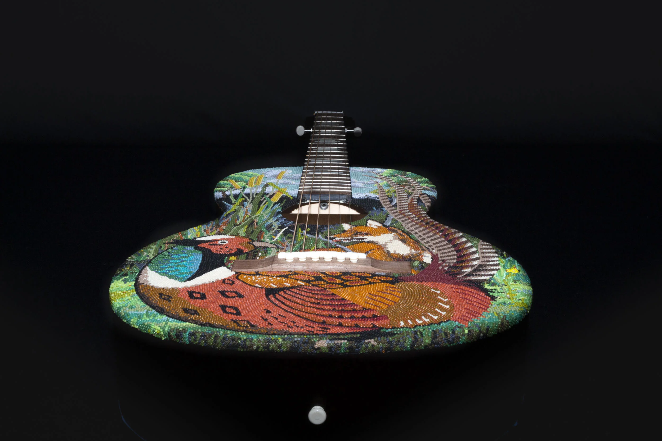  This is the first piece of a trio of guitars with a ‘bird-conflict’ theme. On each guitar there is a common Texas bird- Pheasant, Red Tailed Hawk, and Roadrunner. Each guitar depicts an interaction between 2 animals- the bird and its predator or its