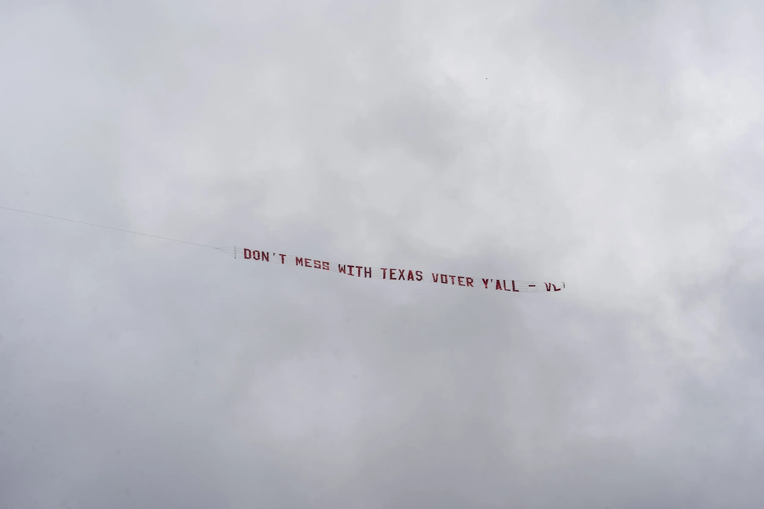  A plane circles the Texas Capitol with a banner that reads, “Don’t mess with Texas voter[s] y’all,” on July 13, 2021. VL stands for Voto Latino, a political organization focused on educating and empowering a new generation of Latinx voters. 