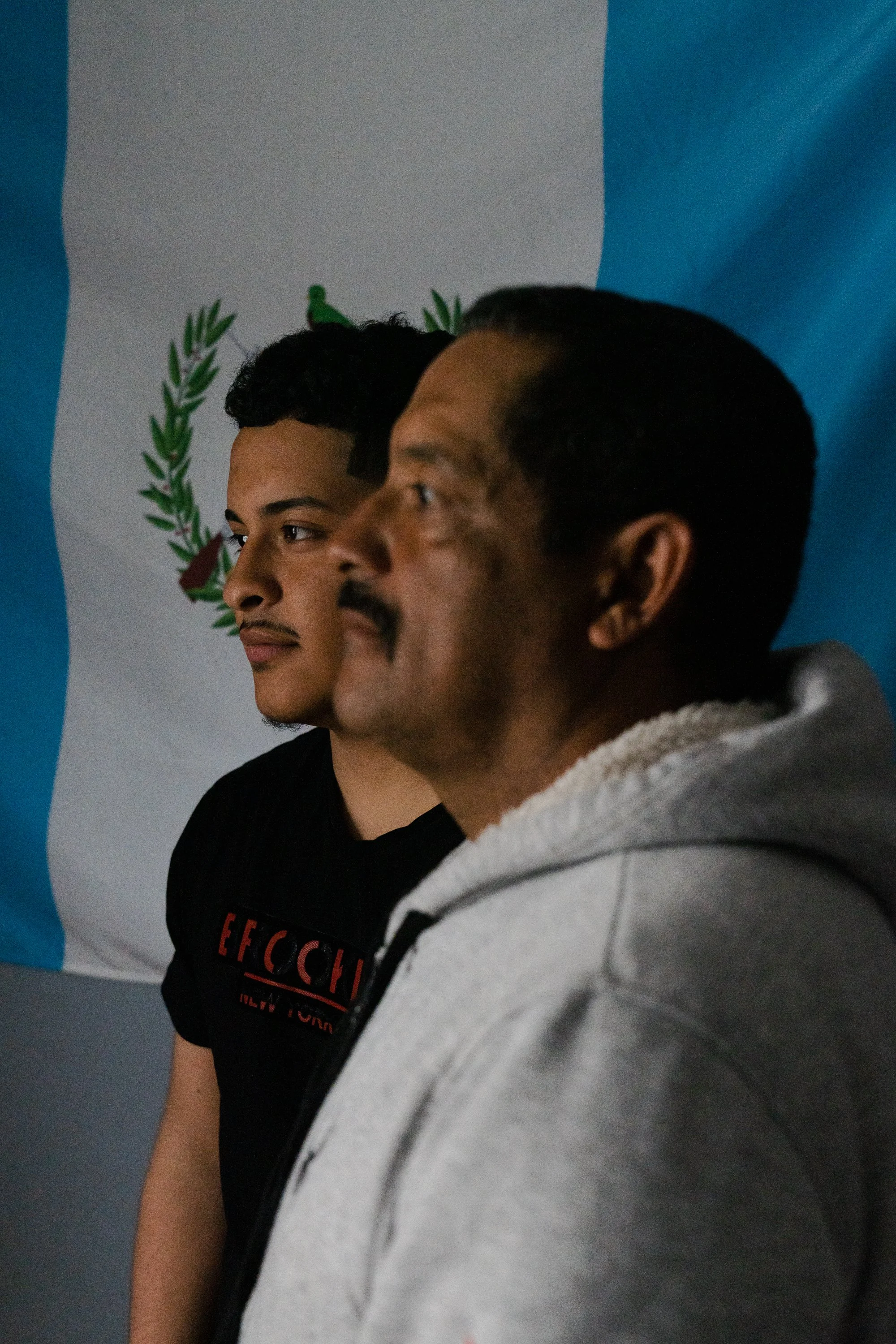  Nery Ortega, 19, poses for a portrait next to his father Ernesto Ortega, 47, in front of a Guatemalan flag at their home in Rhode Island on April 1, 2023. After crossing the US-Mexico border and being separated under Trump’s immigration policy, they