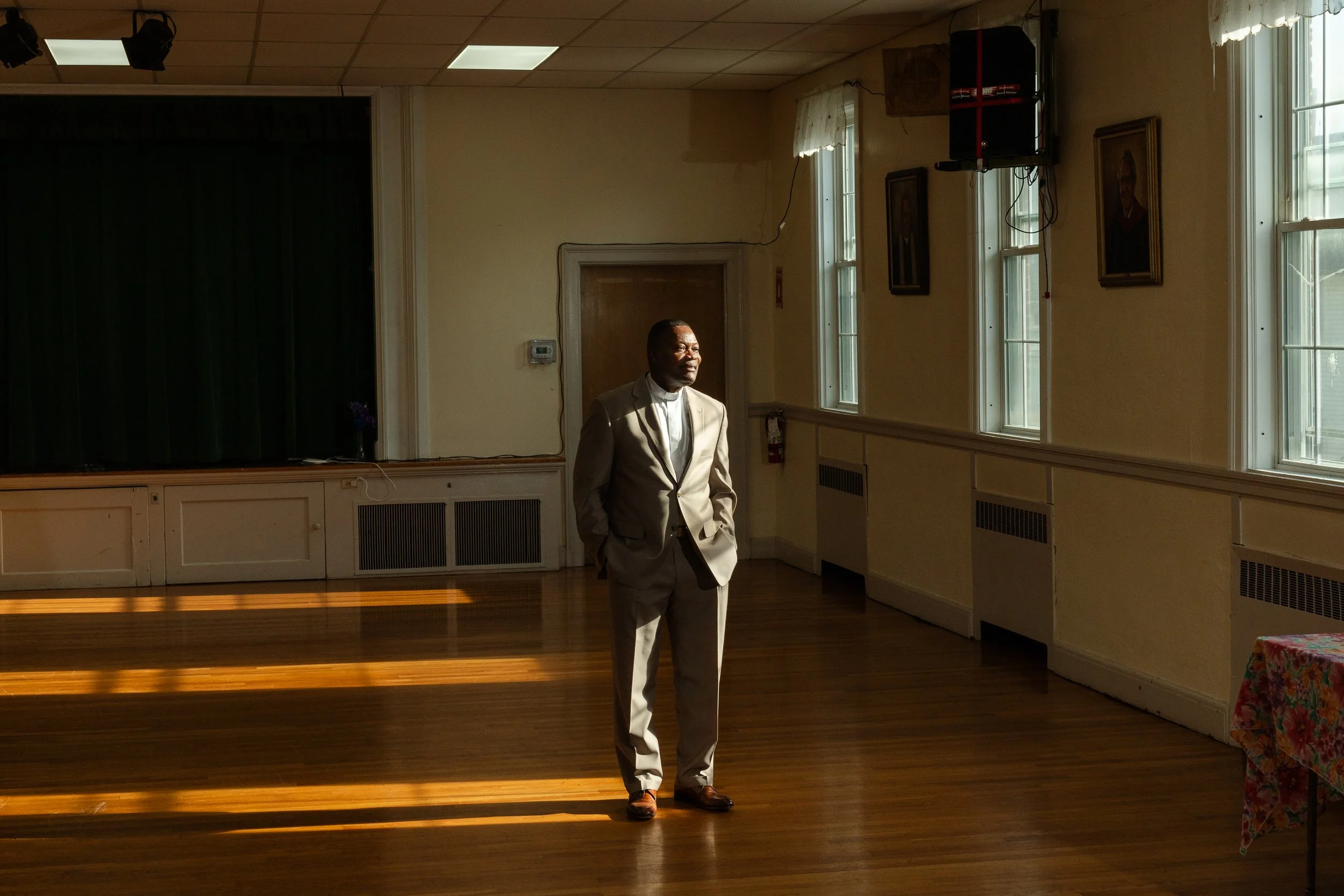  Dieufort Fleurissaint, aka "Pastor Keke,” poses for a portrait after a Sunday service at Total Health Christian Ministries in Milton, Mass. on Dec. 1, 2024. Pastor Keke, a longtime advocate for immigrant rights, has been a lifeline for fellow Haitia