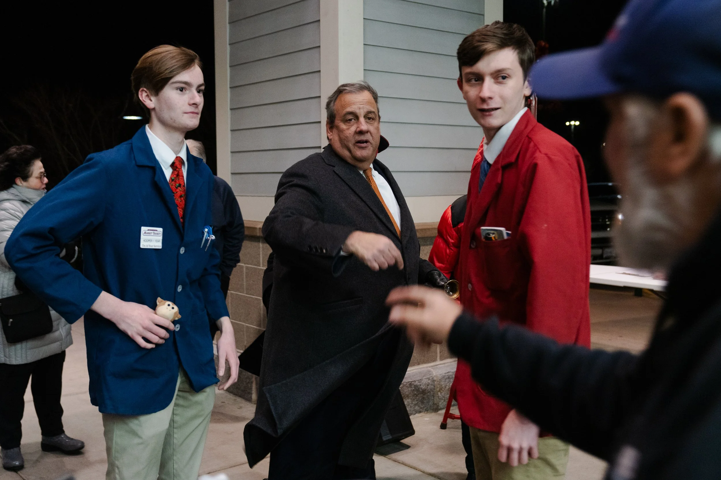  Market Basket employees Kooper Burke, 16, of Derry (left) and Brendan McCoy, 20, of Auburn (right) wait for a photo with GOP candidate and former New Jersey Gov. Chris Christie as he greets people while ringing the Salvation Army bells at Market Bas
