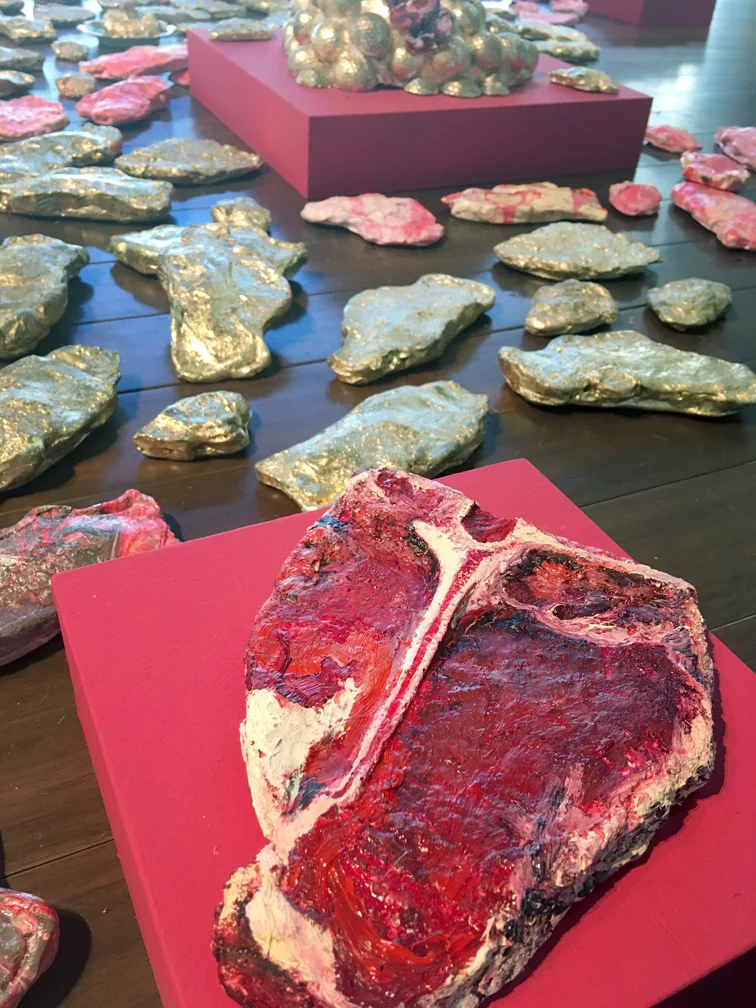 Let them Eat Steak (49% of the World’s carbon emissions are produced by 4% of the population), 2018. Cast Plaster of Paris, gold leaf, acrylic and oil paint Varied size, multi object installation