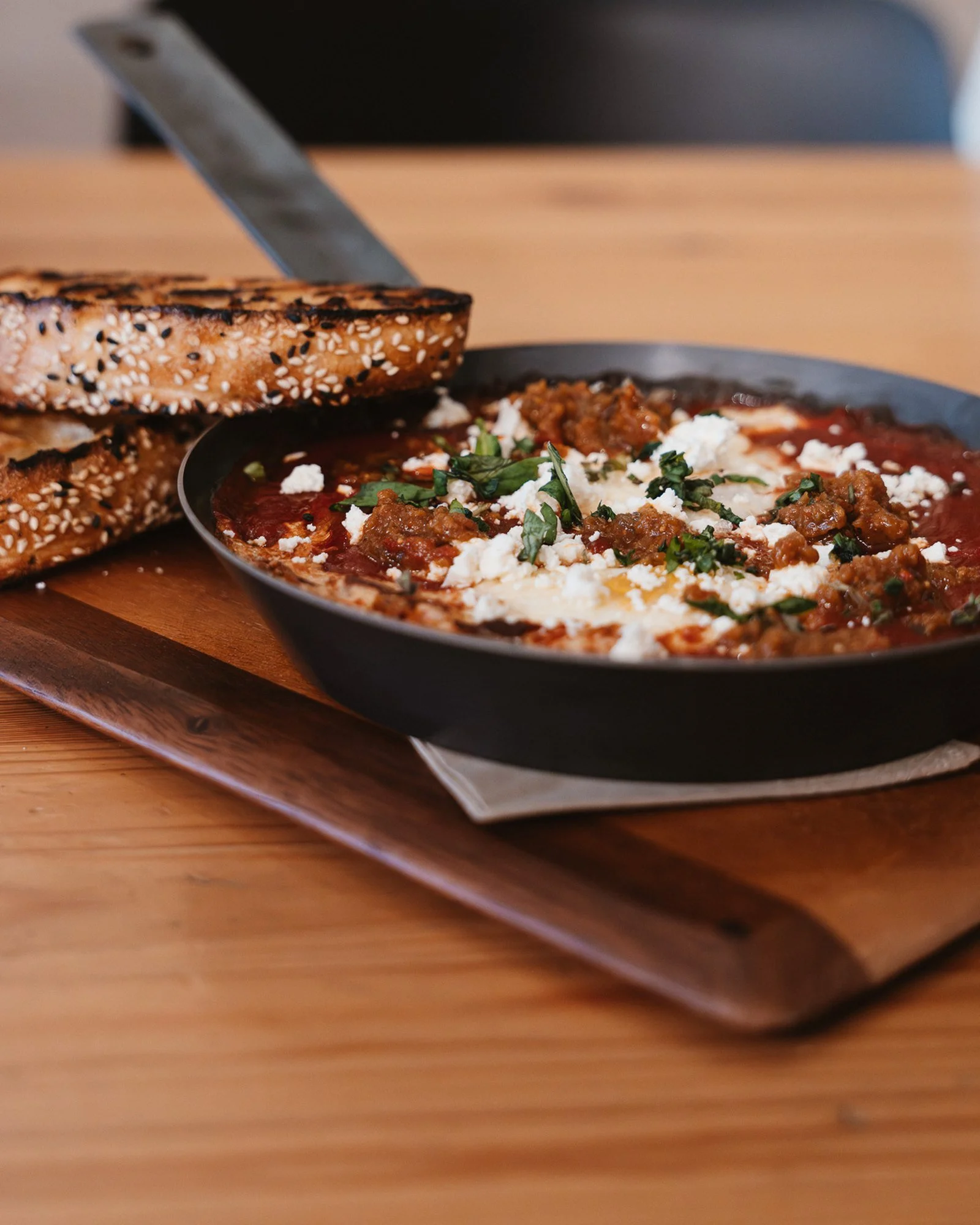 Shakshuka eggs baked in capsicum and tomato ragu with feta, served with Turkish bread