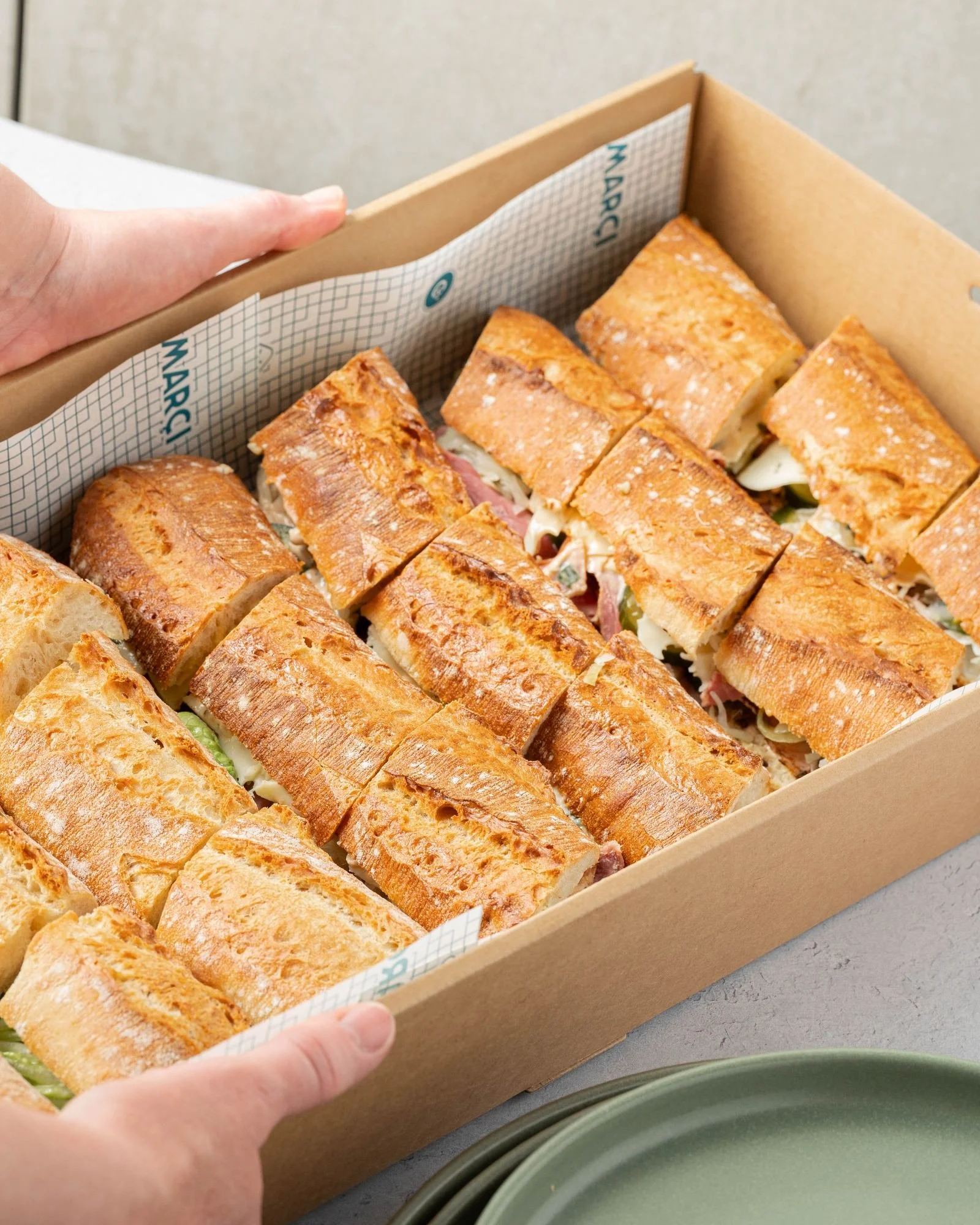 A Marché catering box of freshly baked baguettes being delivered to a Melbourne office