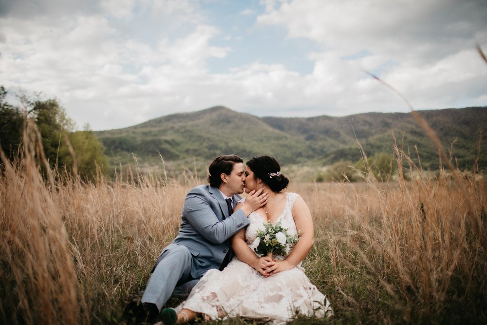cades-cove-elopement-effortless-elopements-bride-and-groom-in-grass.jpg