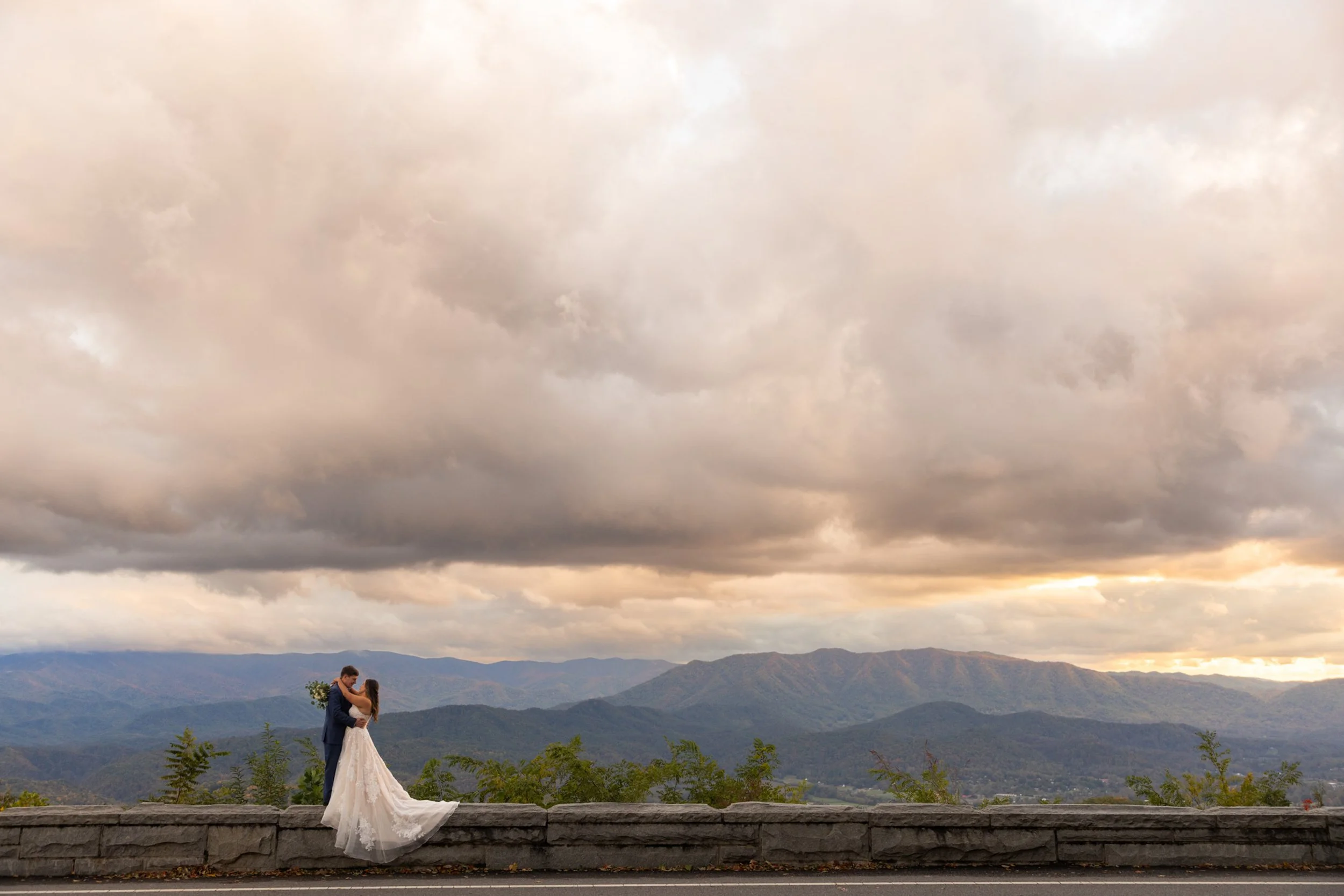 Just married couple embracing on rock wall on the Foothills Parkway