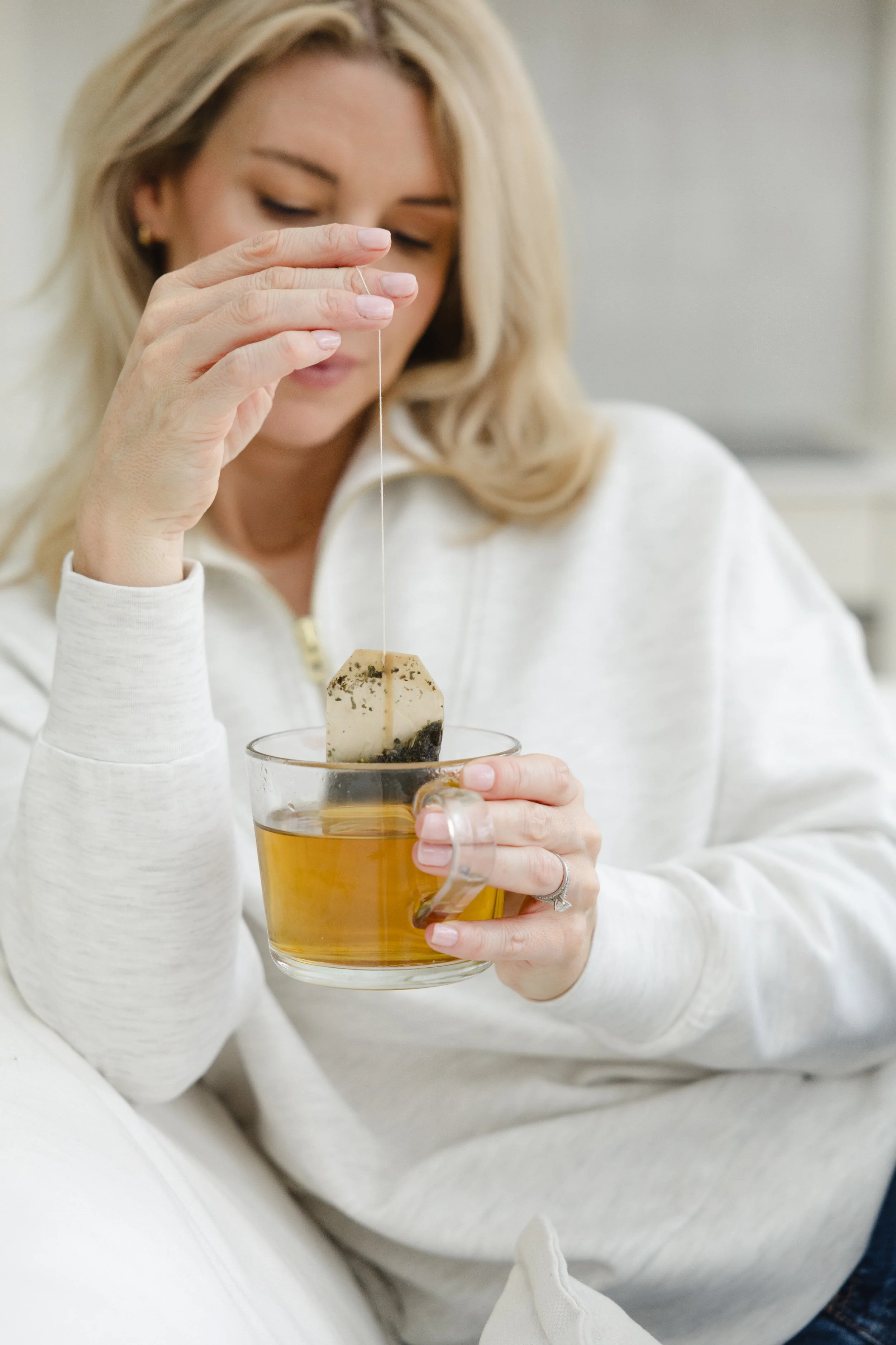 health coach holly with tea bag in a glass mug