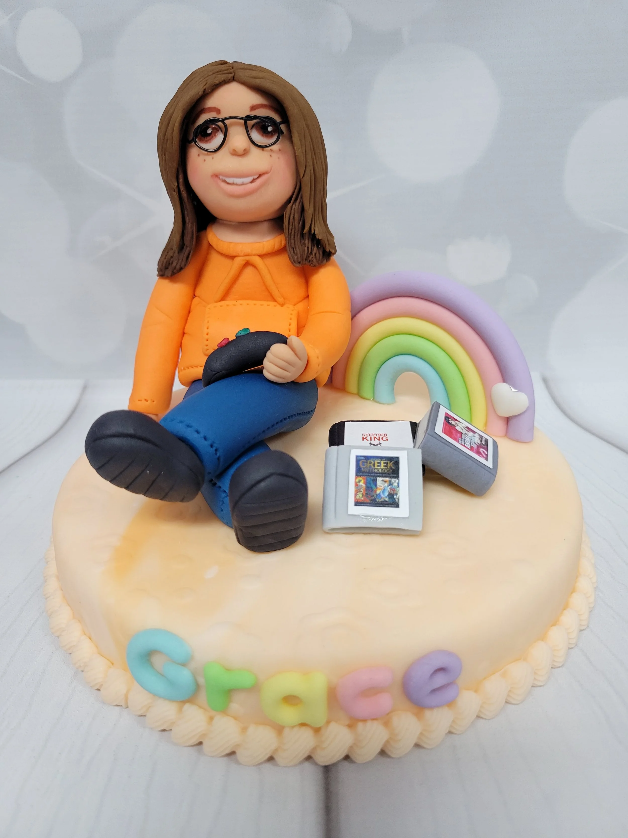 Cake topper for a girl named Grace who loved video games, reading, hoodies and rainbows.