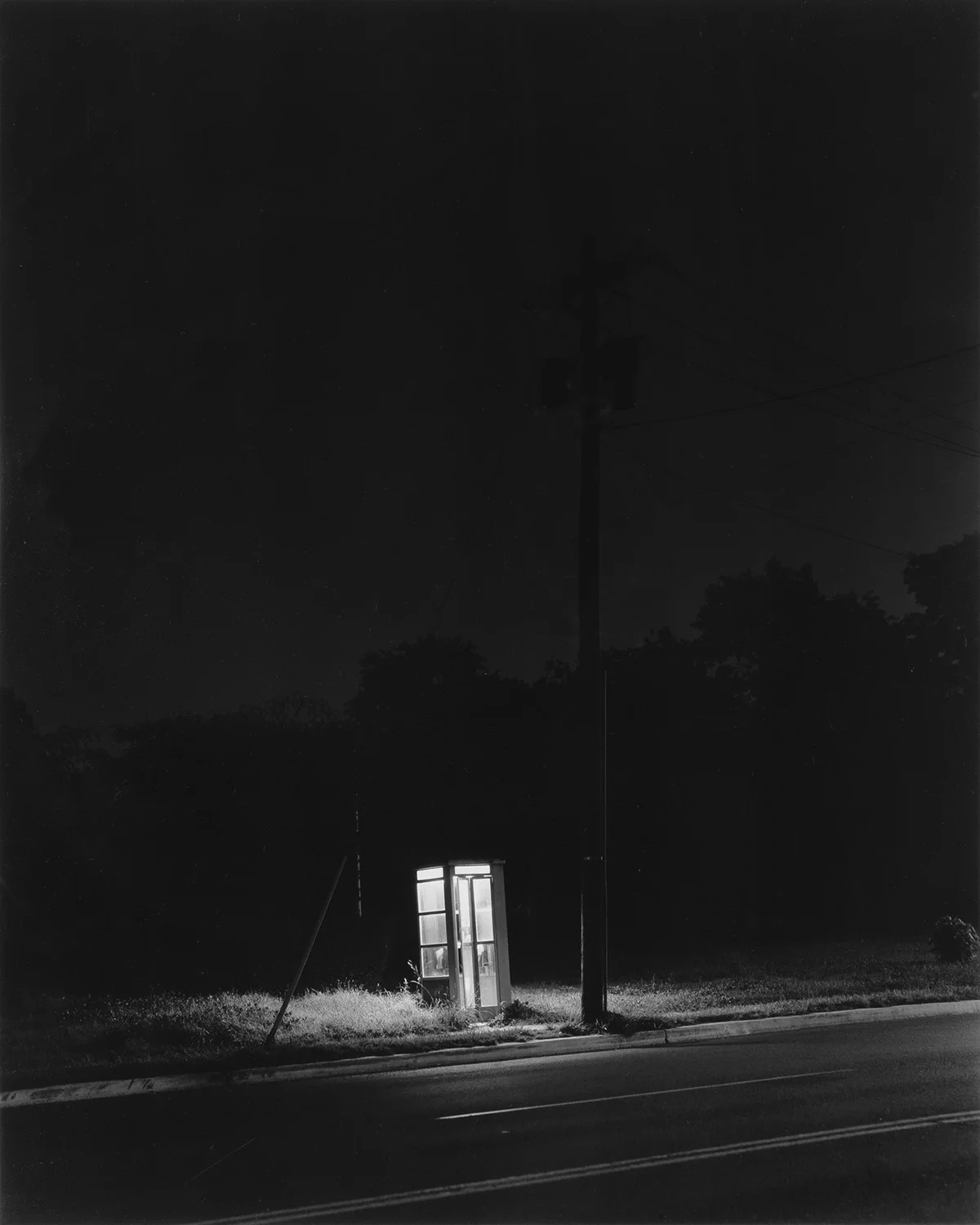  George Tice  ”Phone Booth, 3am, Rahway, NJ, 1974” (Printed 1980)  11”x14” silver gelatin print   Signed “GEO. A. TICE” on mount recto. Titled and dated on verso. 