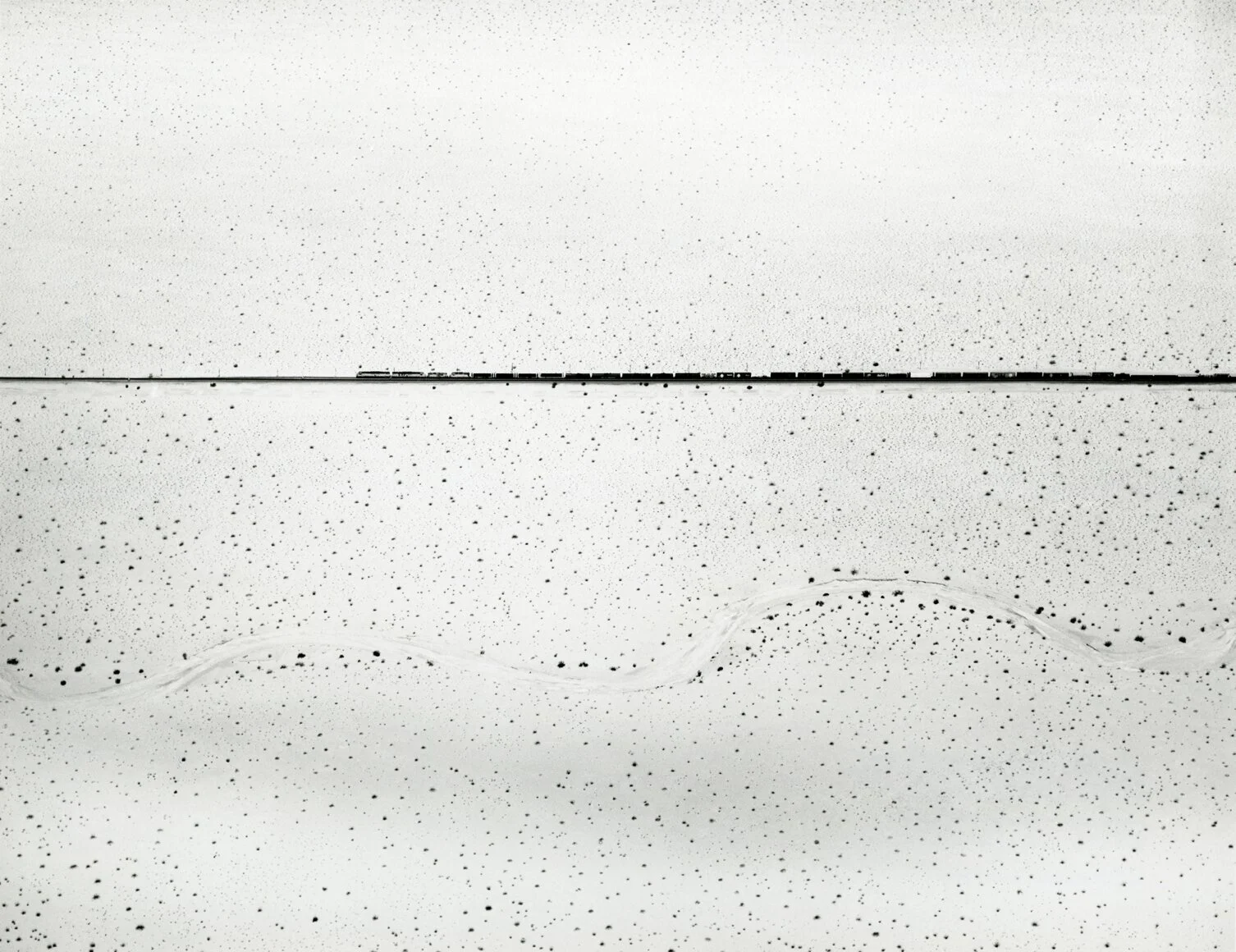 William Garnett  “Train Crossing Desert, Kelso, CA, 1960”  8”x10” silver gelatin print  Signed in pencil on recto. Stamped, titled, dated on verso.