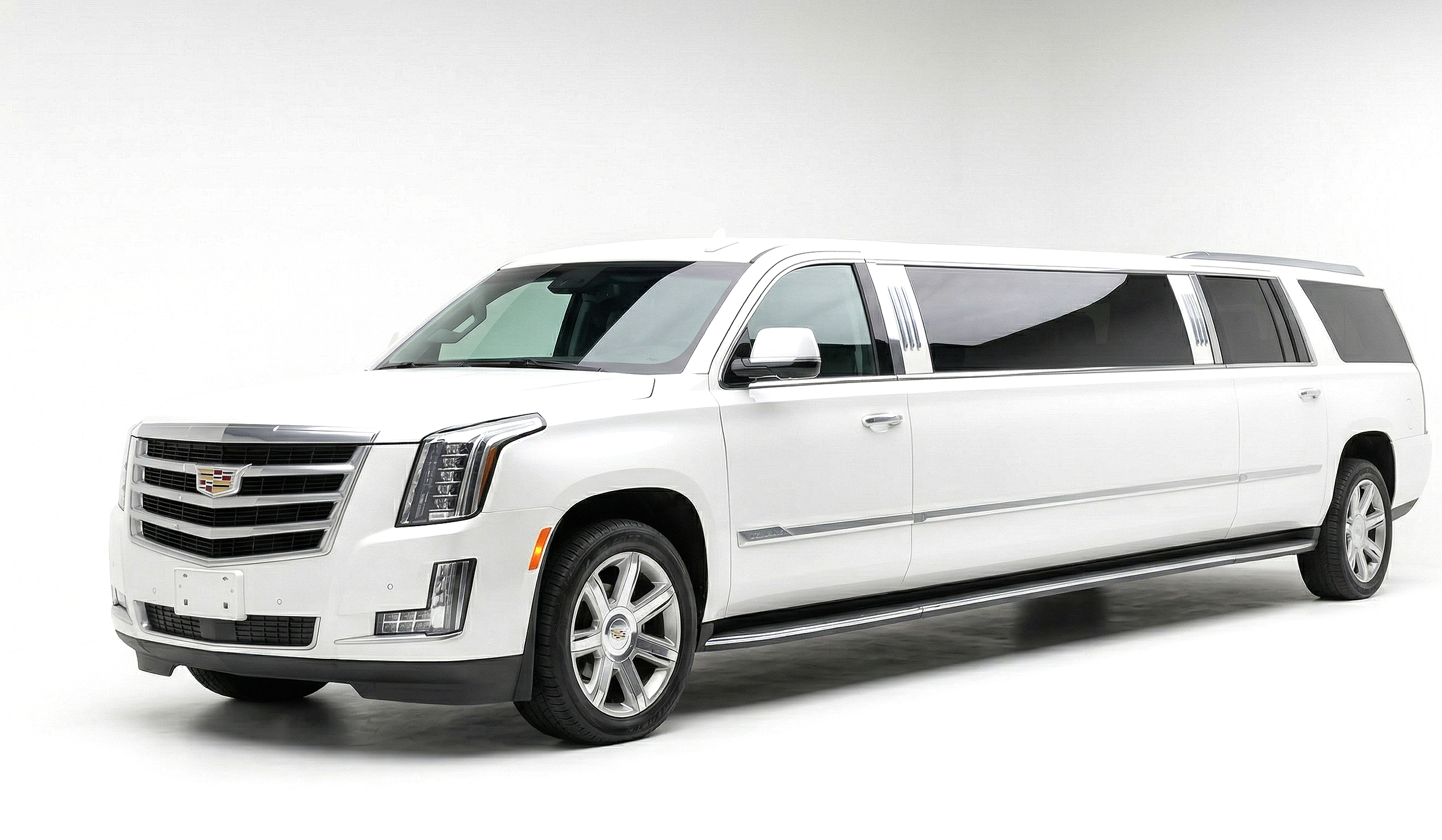 White stretch limousine with Cadillac emblem on front grille, parked against plain white background.