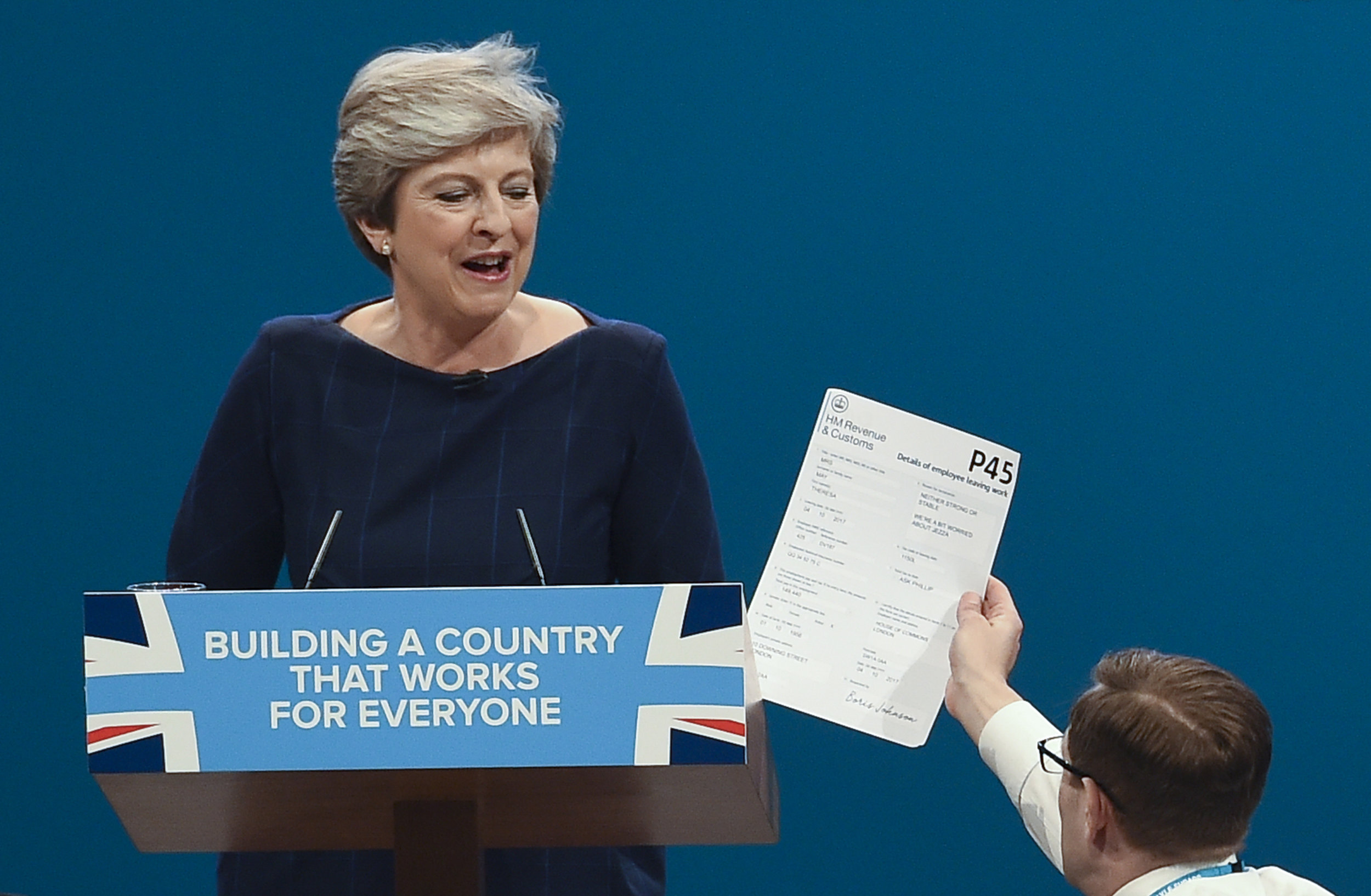  Protester and comedian Simon Brodkin gives a mock P45 to Prime Minister Theresa May MP (L) as she deivers her speech on the final day of the Conservative Party Conference in Manchester.
Photo by Paul Ellis, 04 October 2017
 