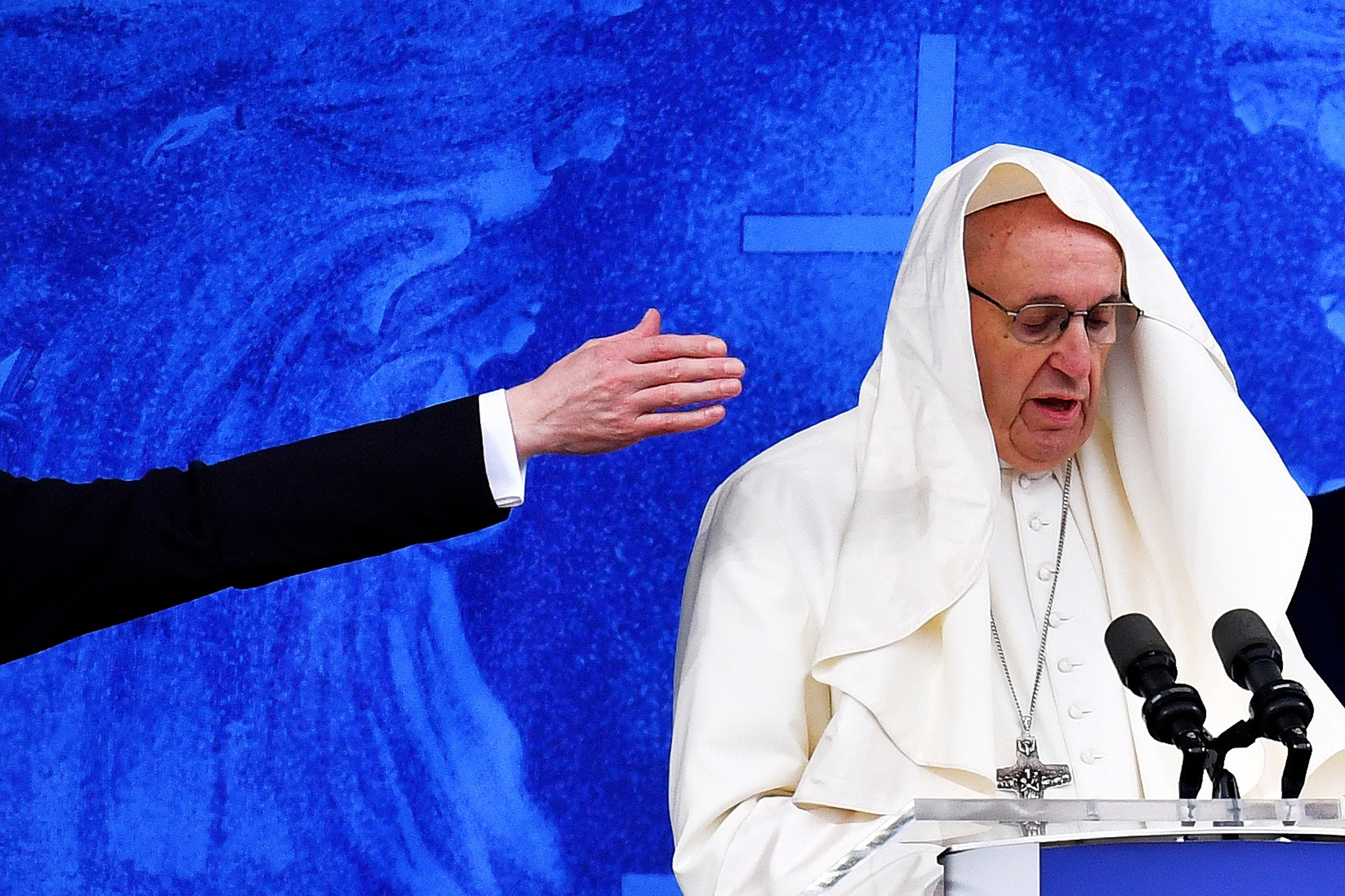  One of his staff attempts to move part of Pontiff�s clothing blown onto his head as Pope Francis leads the Angelus at the Knock Shrine in Knock, Ireland.
Photo by Dylan Martinez, 26 August 2018
 