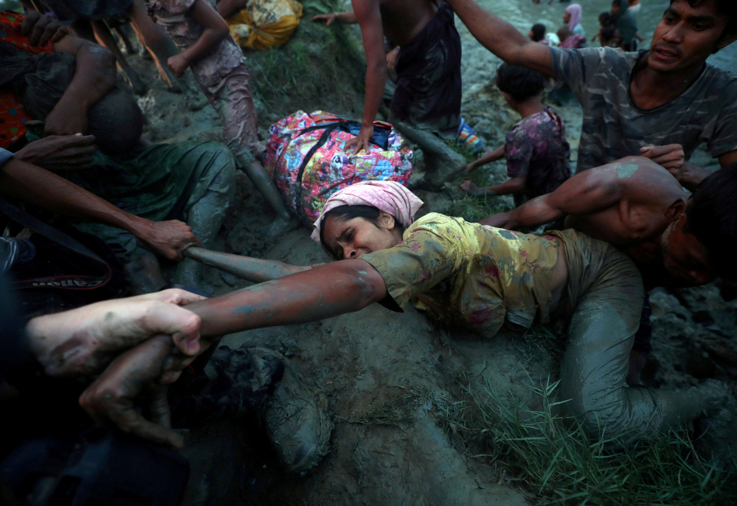  Photographers help a Rohingya refugee to come out of Naf River as they cross the Myanmar-Bangladesh border in Palong Khali, near Cox's Bazar, Bangladesh.
Photo by Hannah McKay, 01 November 2017
 