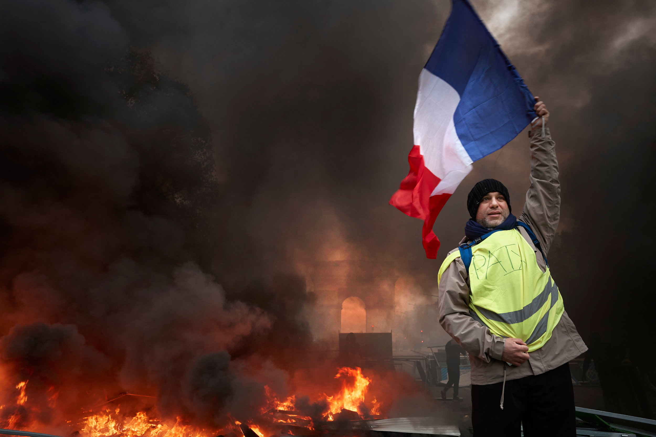  A Gilets Jaunes, or yellow vest, protestor waves the French Tricolour flag proudly, during demonstrations on the Champs Elysees in Paris as thousands turn out in the French capital to protest against the rising fuel and living costs implemented by P