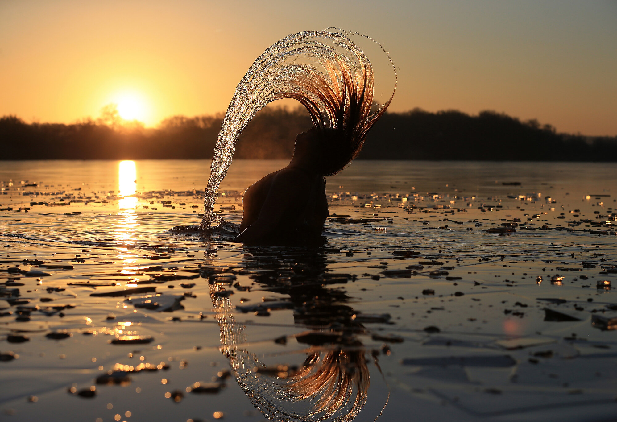  An open water swimmer resurfaces during her socially-distanced dawn swim after breaking the ice in freezing conditions near Scunthorpe. Photo: Lindsey Parnaby/AFP, 09 January 2021 