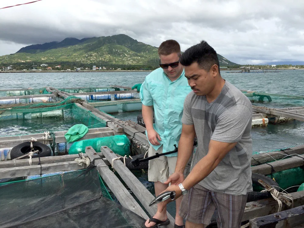 Luke Keeton fishing with our customer at a cage culture environment in Vietnam
