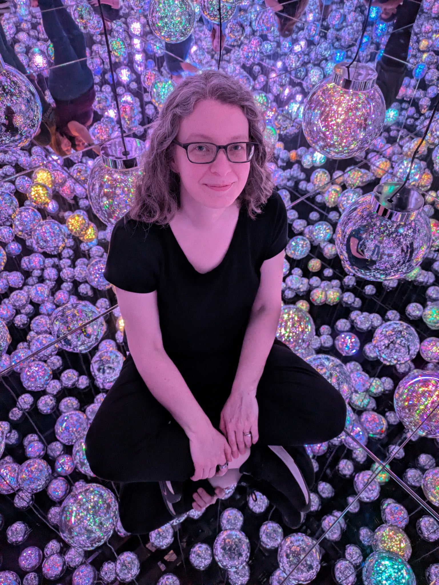 Amélie sitting among glowing orbs