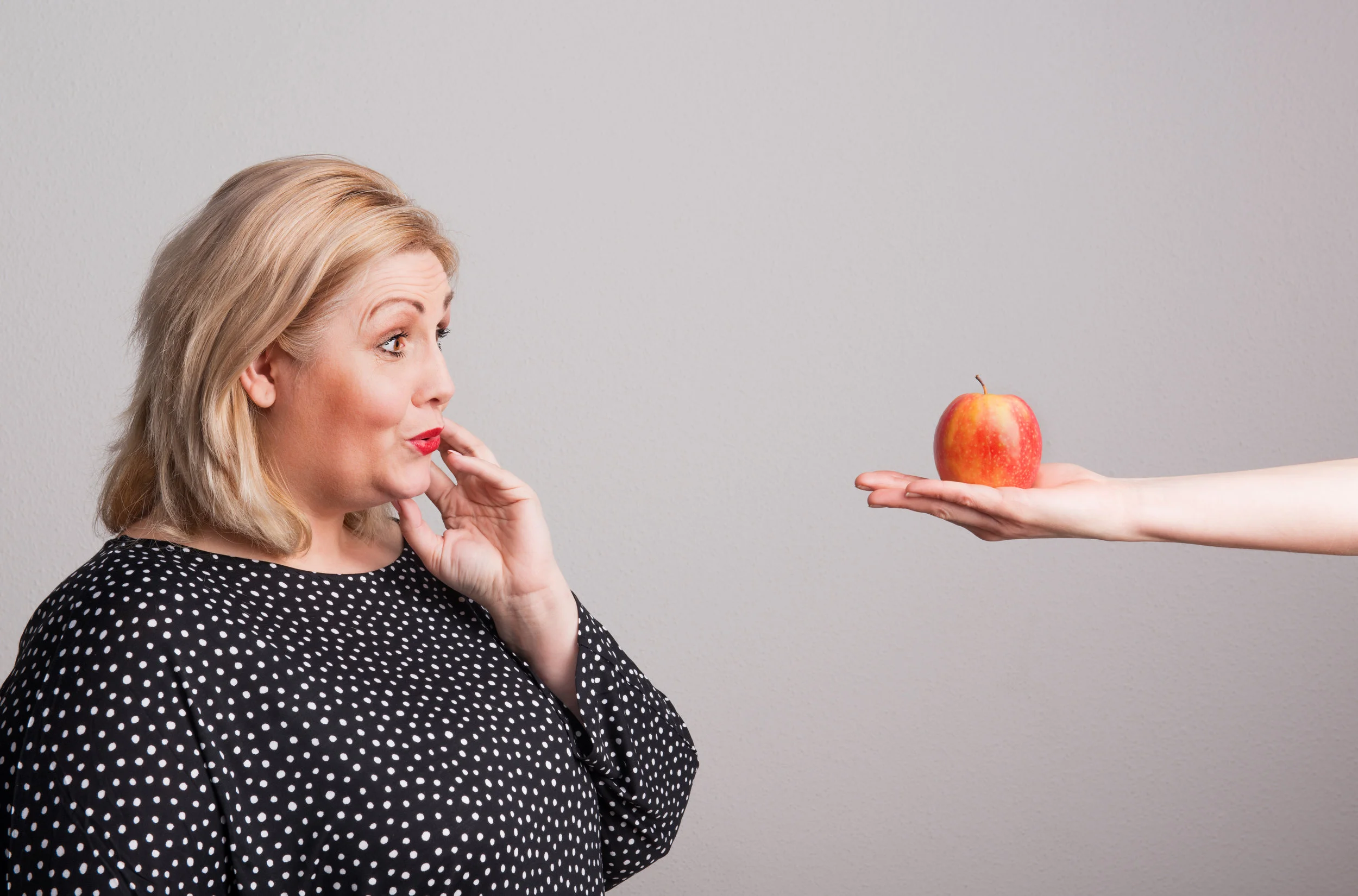 a-female-hand-giving-an-apple-to-an-attractive-A2K8LMC.jpg