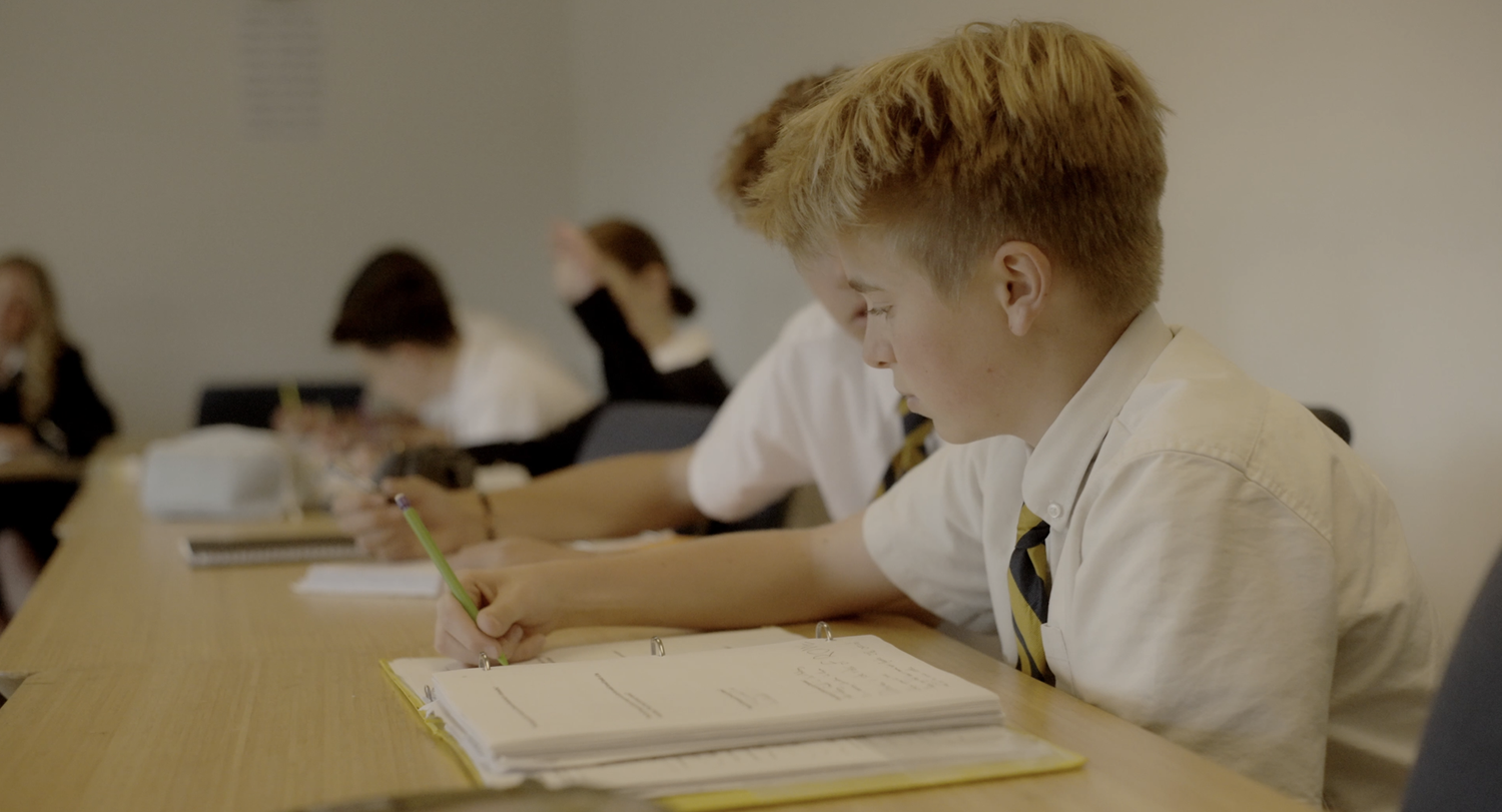 Students writing in their notebooks during a Humanities class