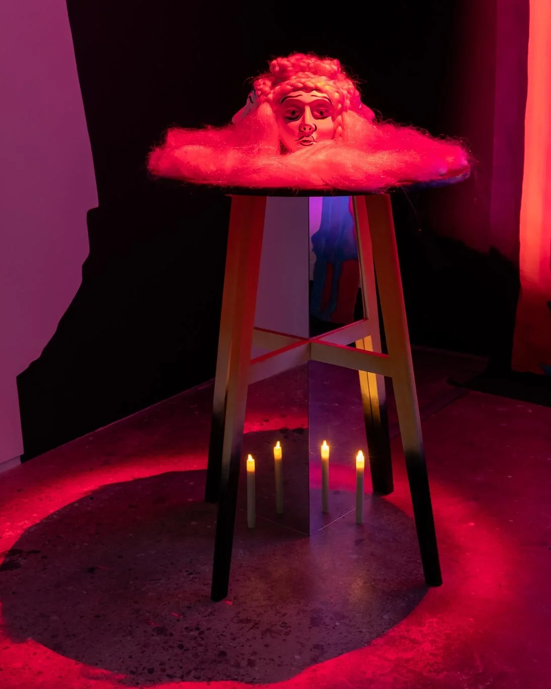 She, 2019, Pepper’s Ghost hologram, mirror plexiglass, table, masks, fake candles