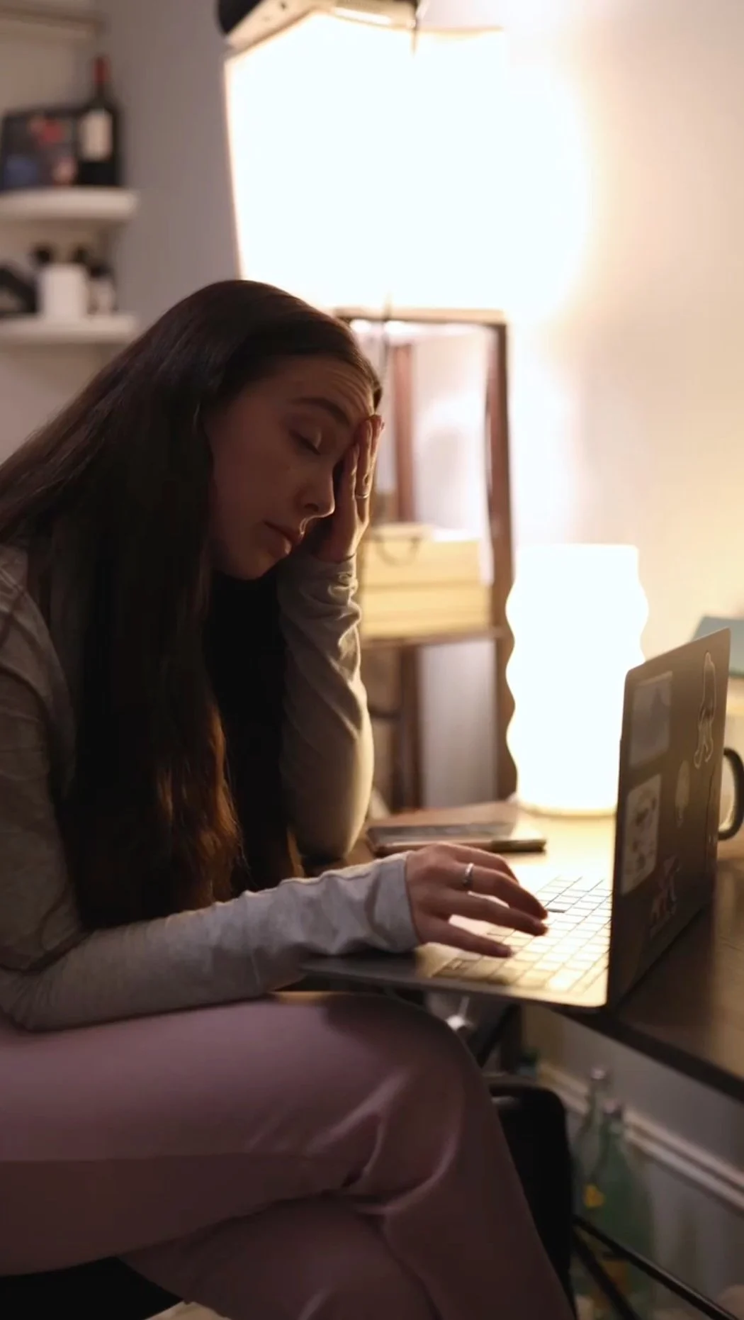 Professional woman working extended hours on laptop at night illustrating 996 work culture and need for fitness routine