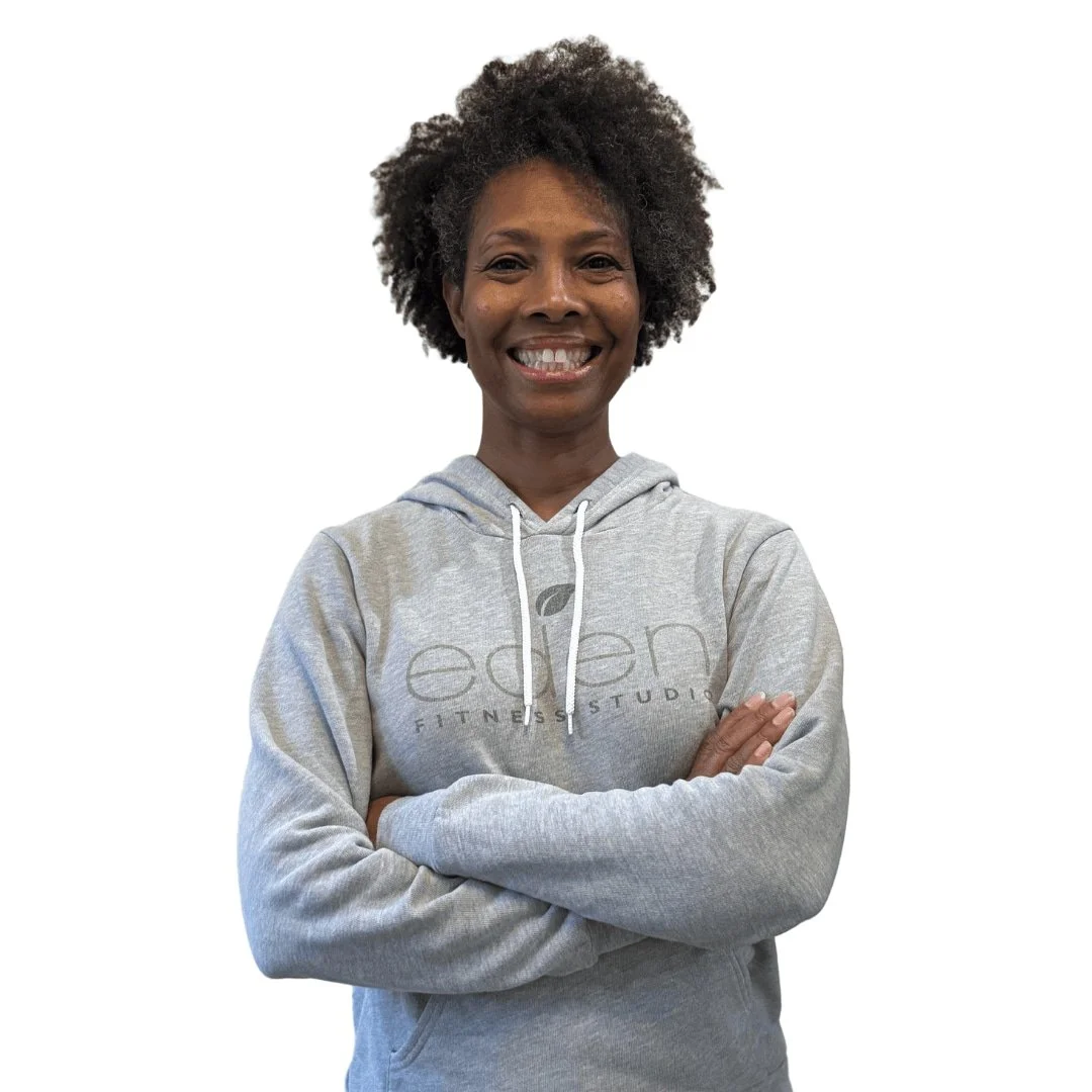 Woman smiling, wearing a grey woody with an Eden Fitness Studio logo