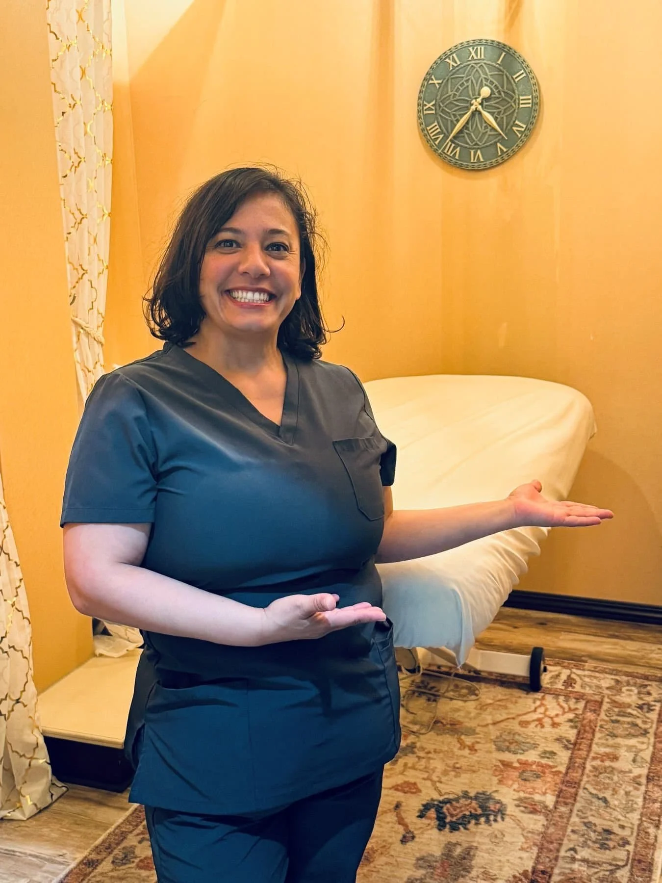 Woman standing in front of massage table at Eden Fitness Studio.