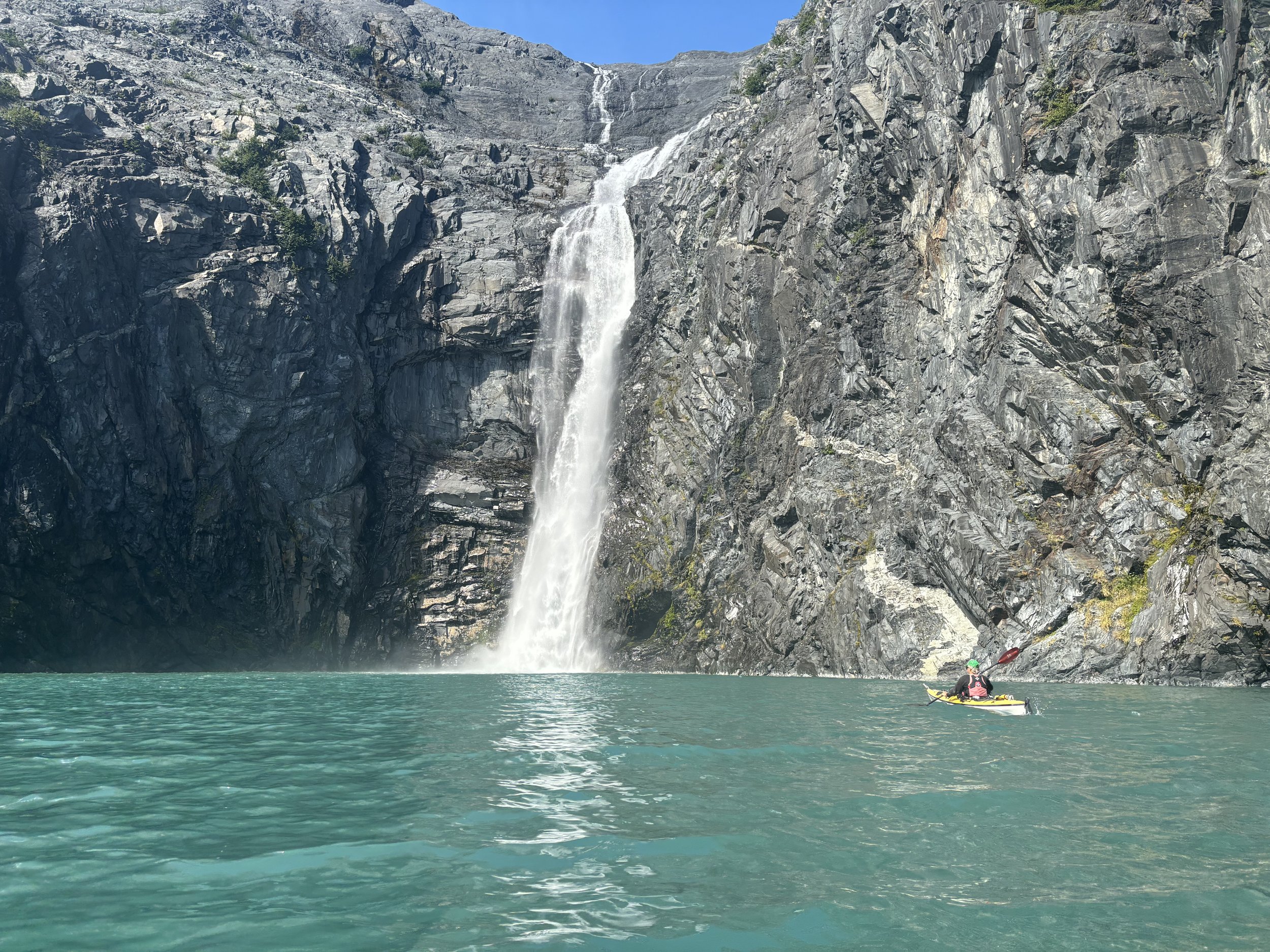 paddler at a waterfall in alaska